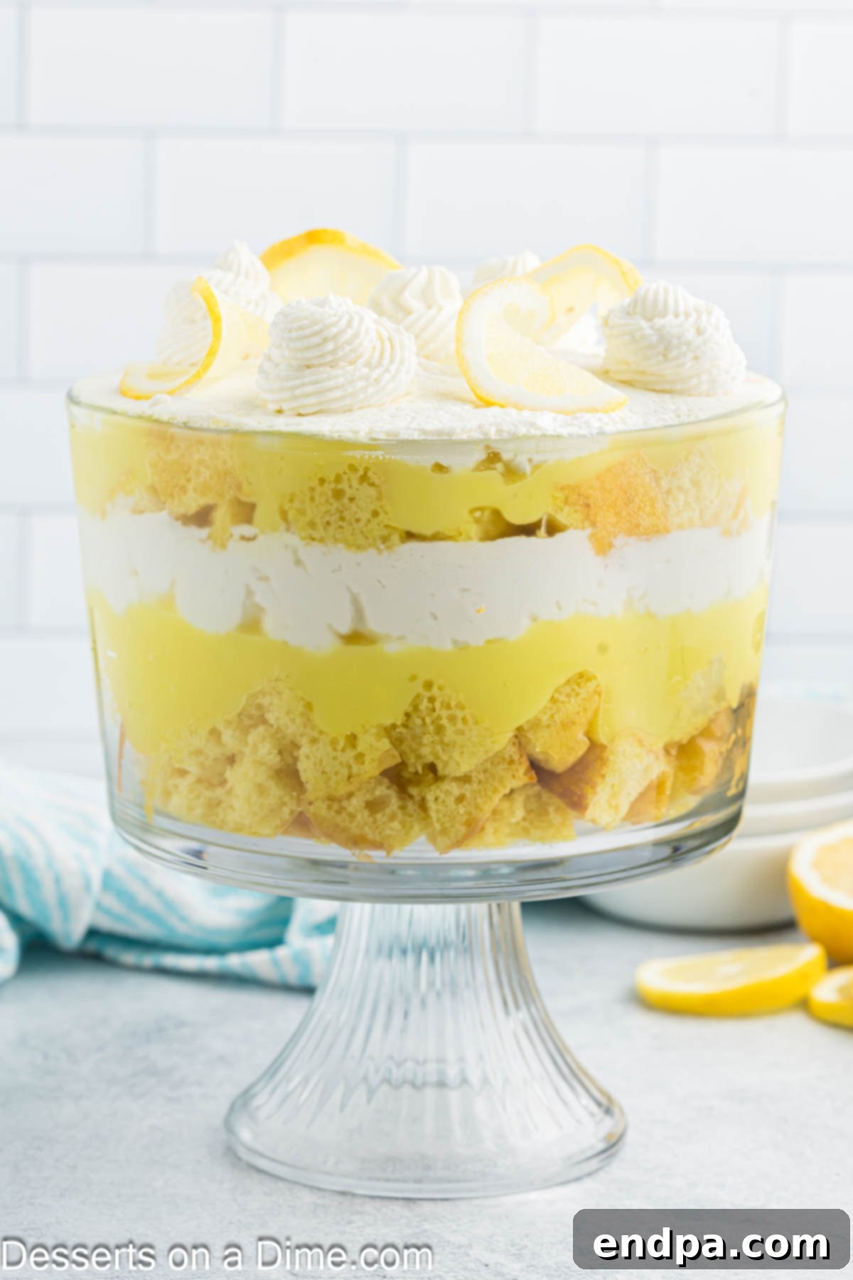 A stunning lemon trifle layered in a clear glass dish, ready to be served, showcasing its beautiful yellow and white layers.