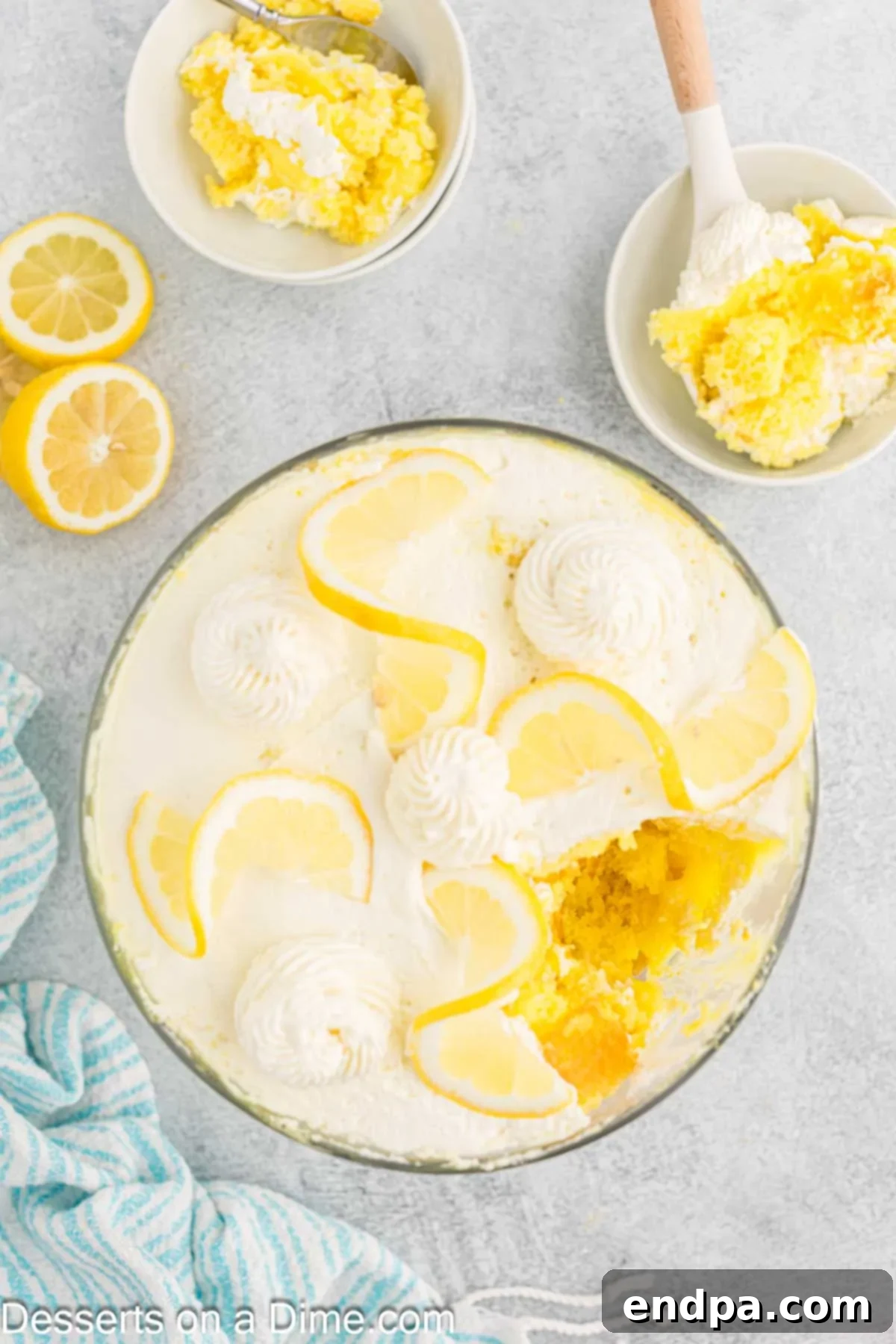 The finished lemon trifle, garnished with fresh lemon slices and mint leaves, presented beautifully in a glass serving dish.