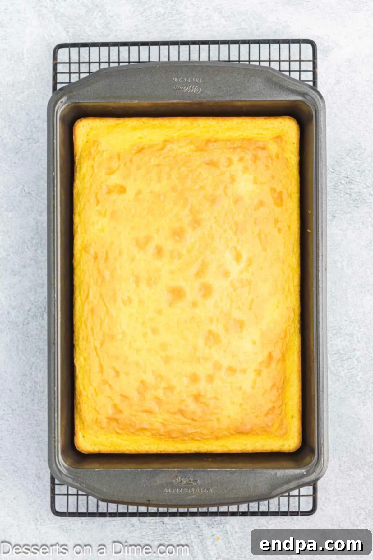Freshly baked lemon cake cooling in a rectangular baking pan.