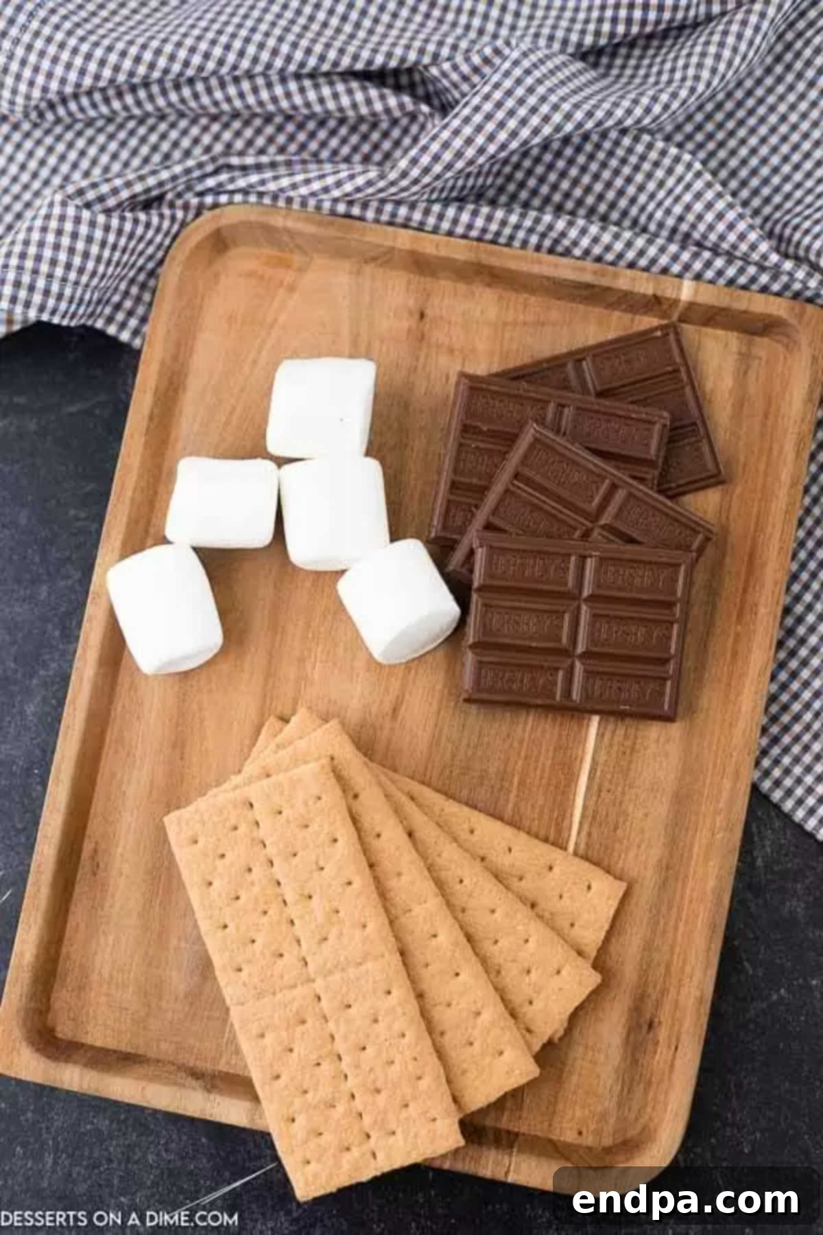 Oven baked smores are so convenient and you still can enjoy all the ooey gooey marshmallows and decadent chocolate. Try oven smores. Graham crackers, chocolate bar, and marshmallows laid out for oven s'mores