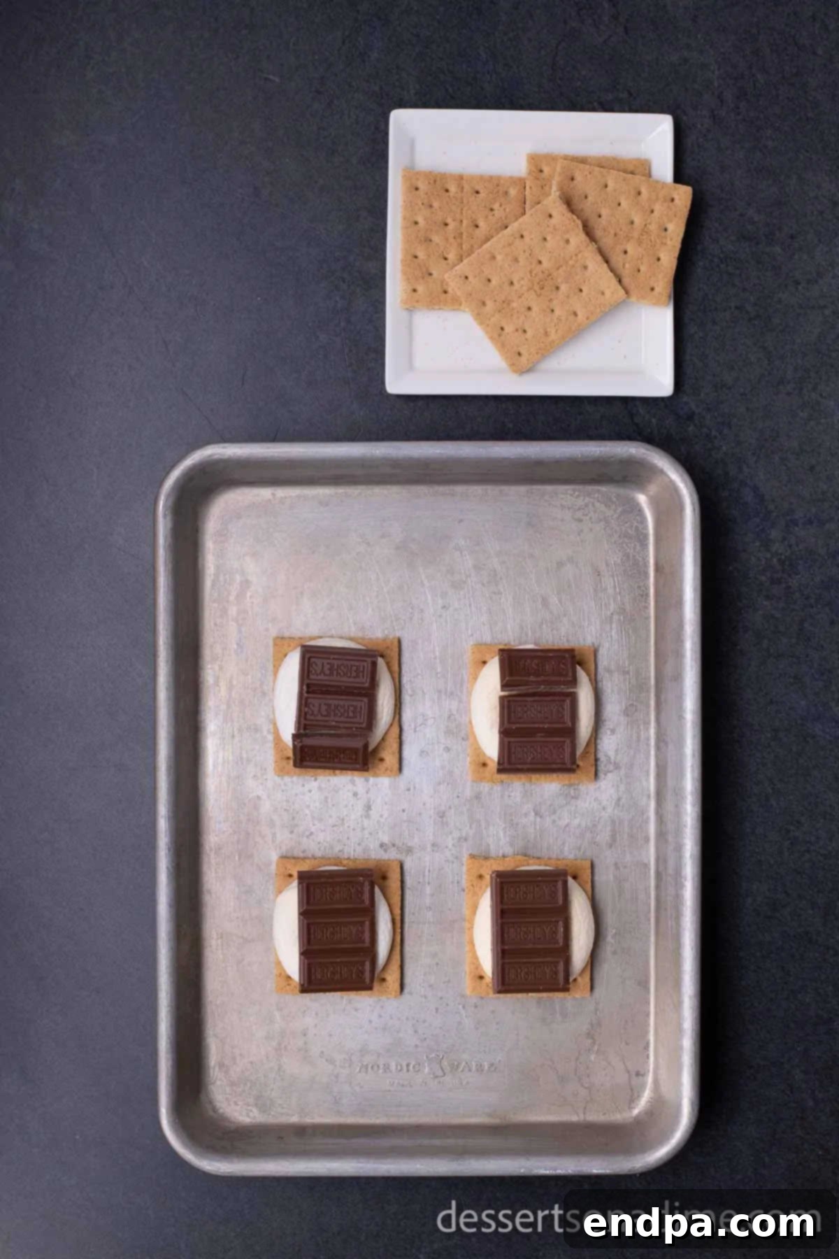 Perfect Oven S'mores: Your Campfire-Free Indulgence 5 Topping roasted marshmallows with chocolate pieces and the remaining graham cracker halves