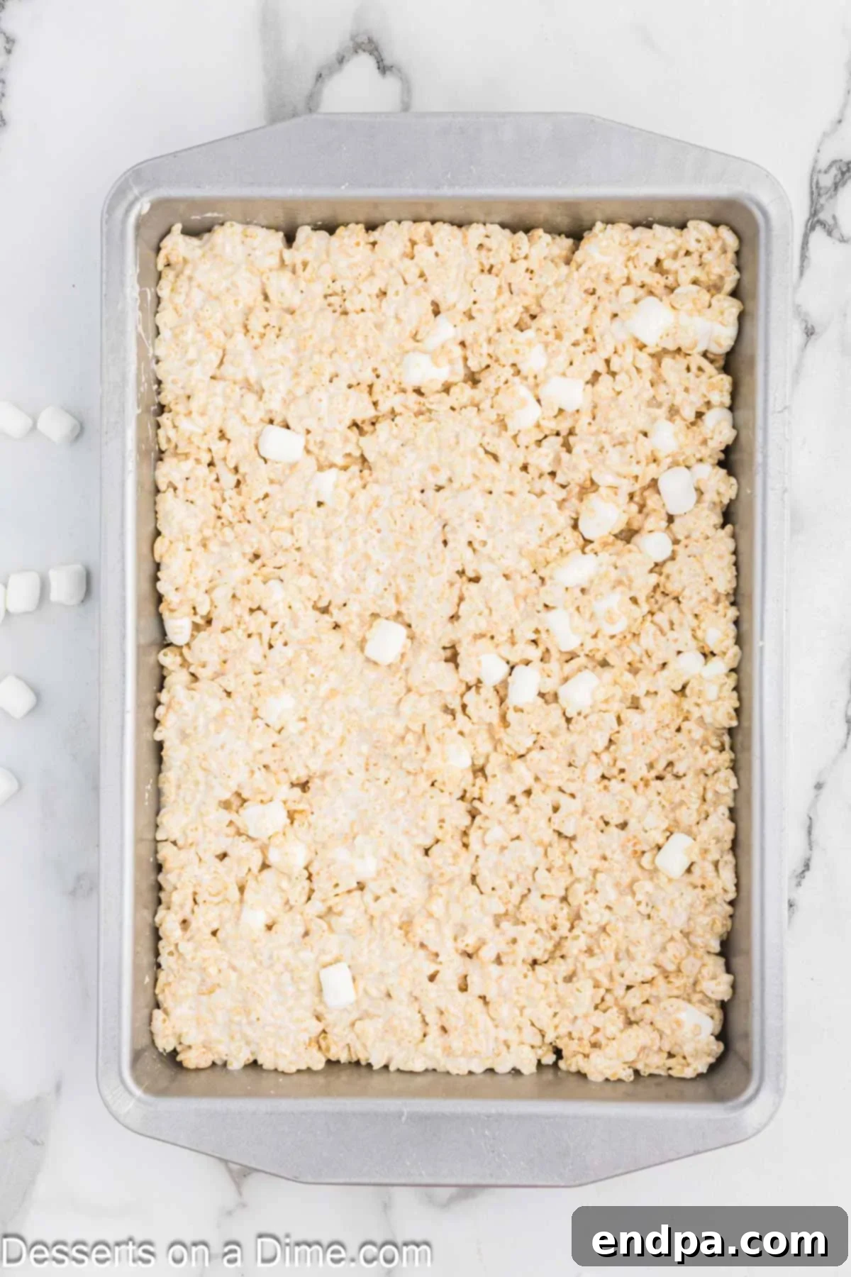 Marshmallow dream bar mixture pressed evenly into a greased baking dish.
