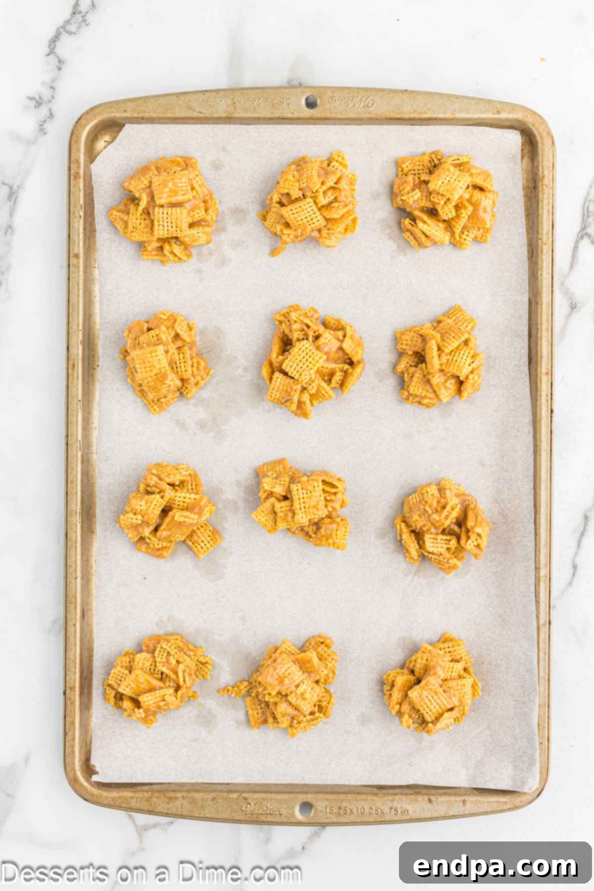Chex Peanut Butterscotch Crunch 6 Uniform clusters of Chex Scotcheroo base mixture arranged on a parchment-lined baking sheet.