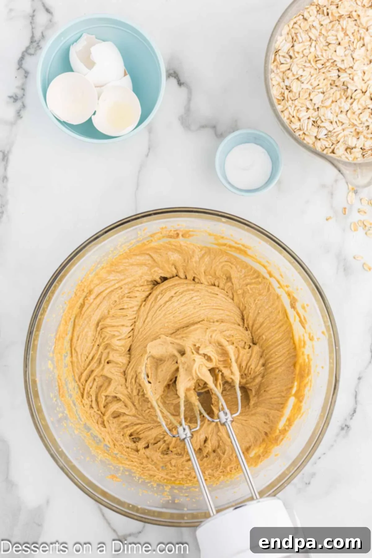 Softened butter and creamy peanut butter being creamed together in a large mixing bowl.