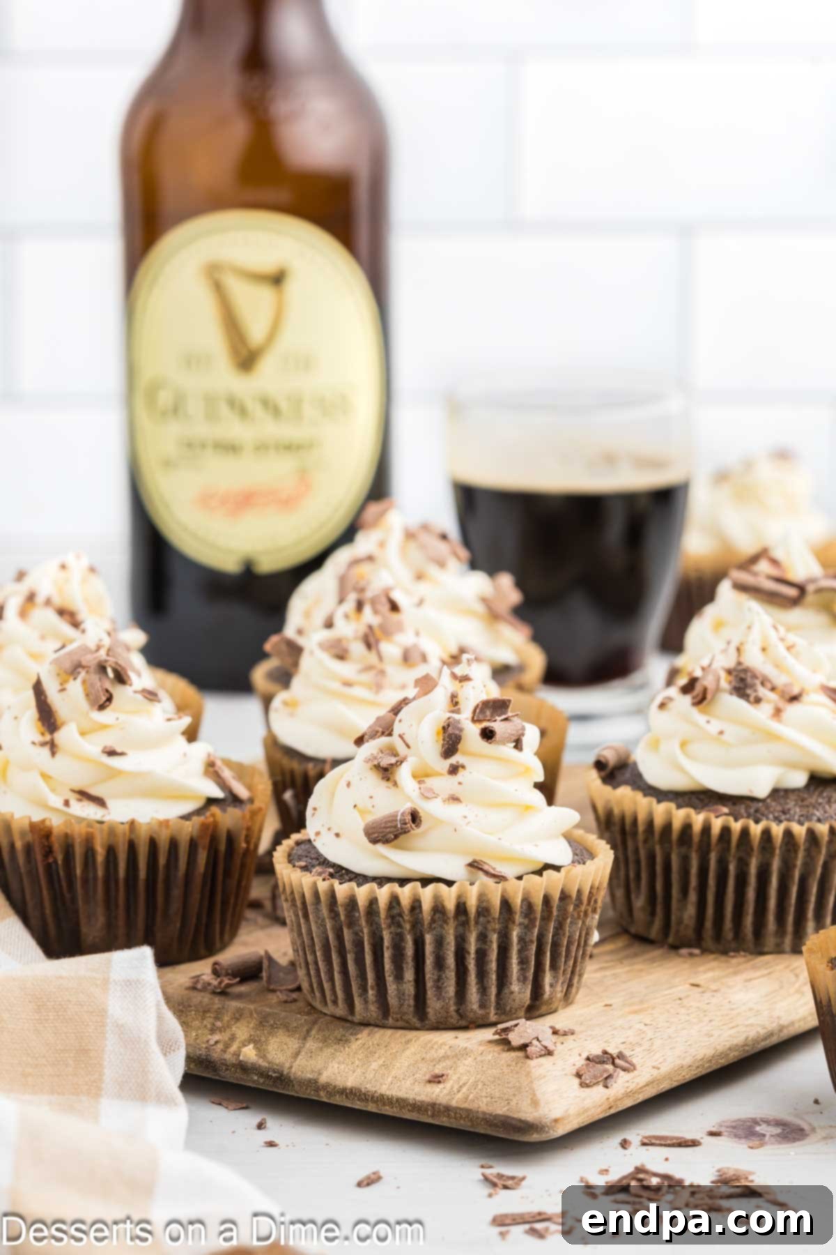 Guinness Cupcakes arranged together on a wooden tray, showing the dark cake and white frosting.