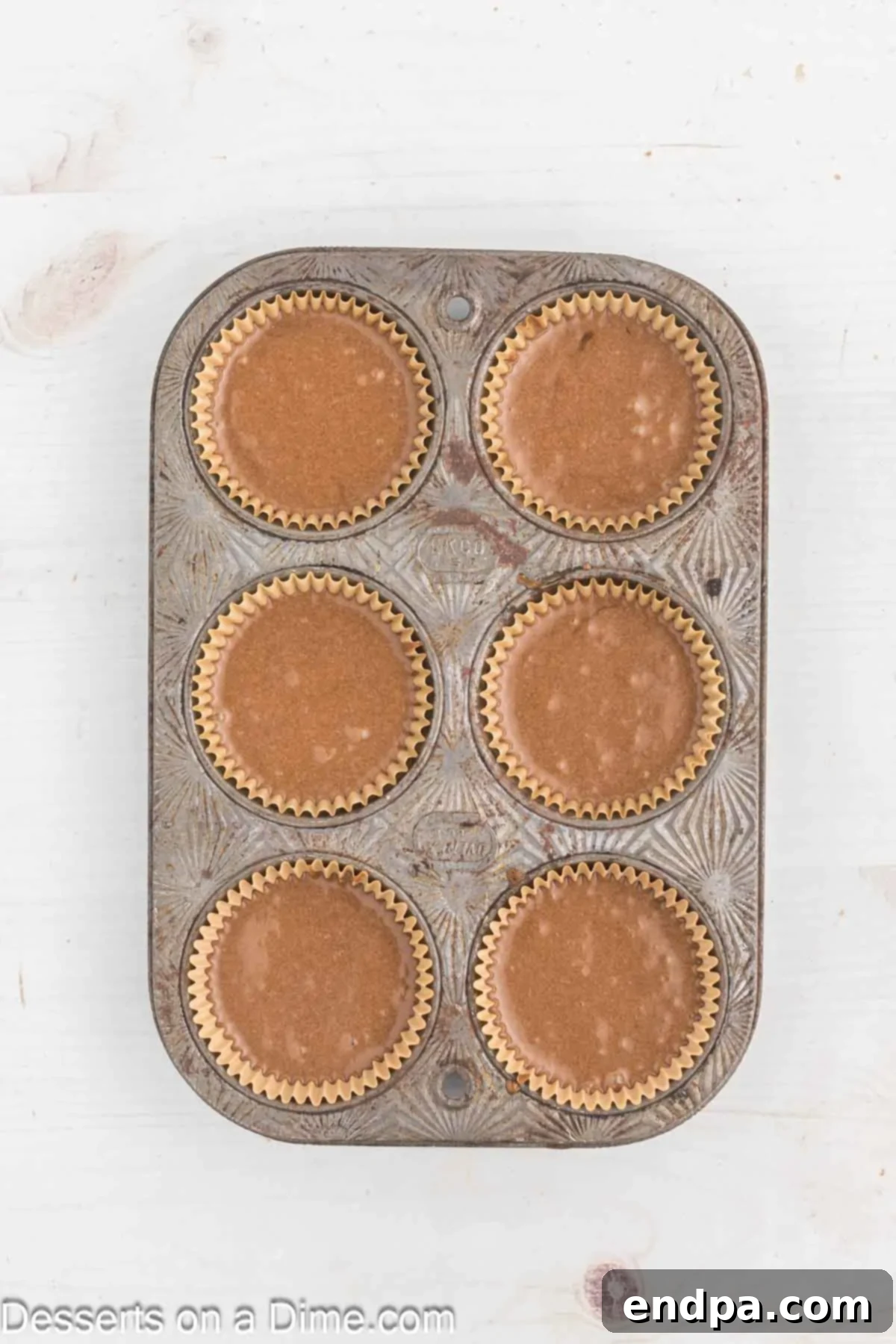 Cupcake batter poured into muffin tins, ready for baking.