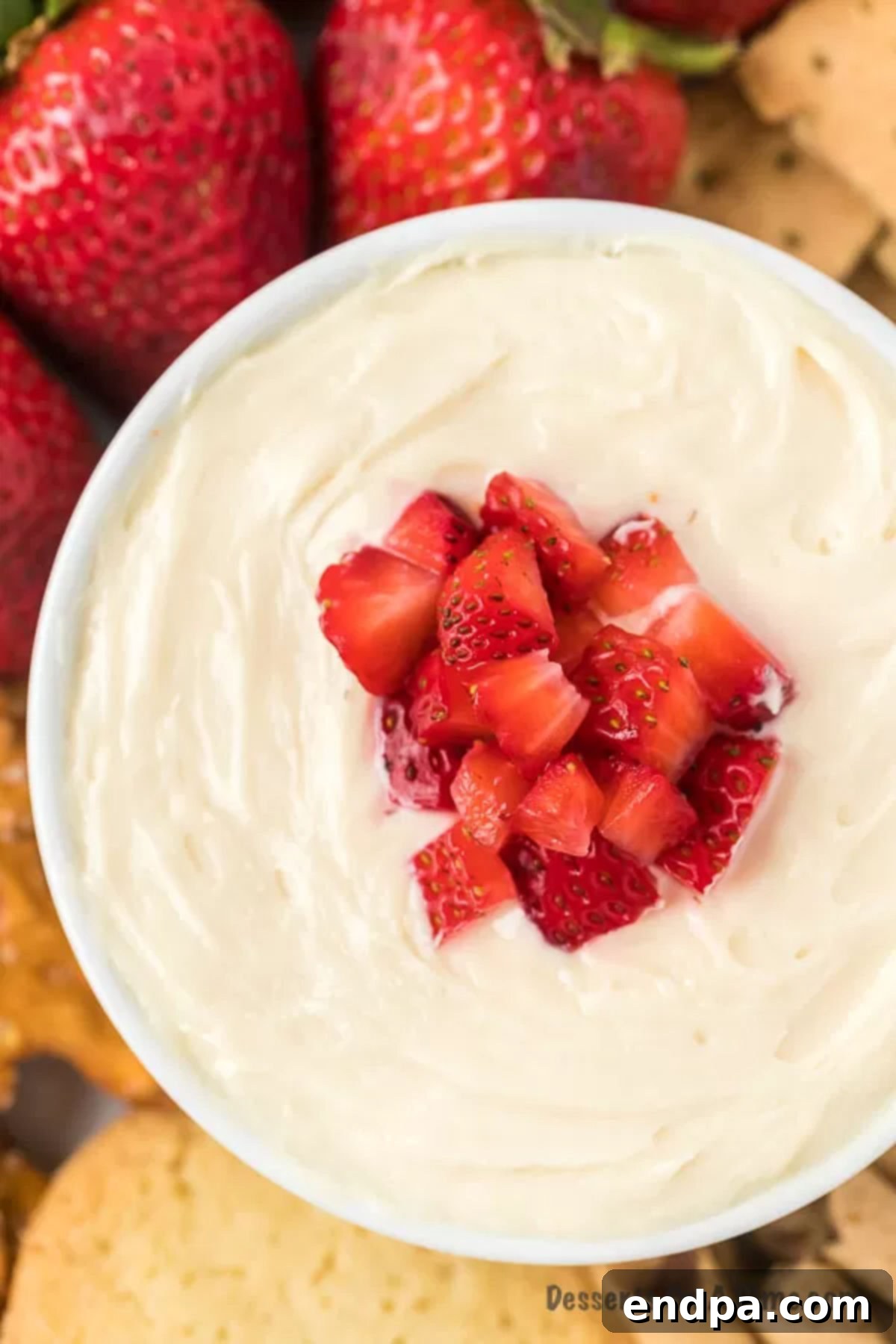 Heavenly Cheesecake Dip 2 Cheesecake dip in a white bowl topped with vibrant diced strawberries, ready for serving.