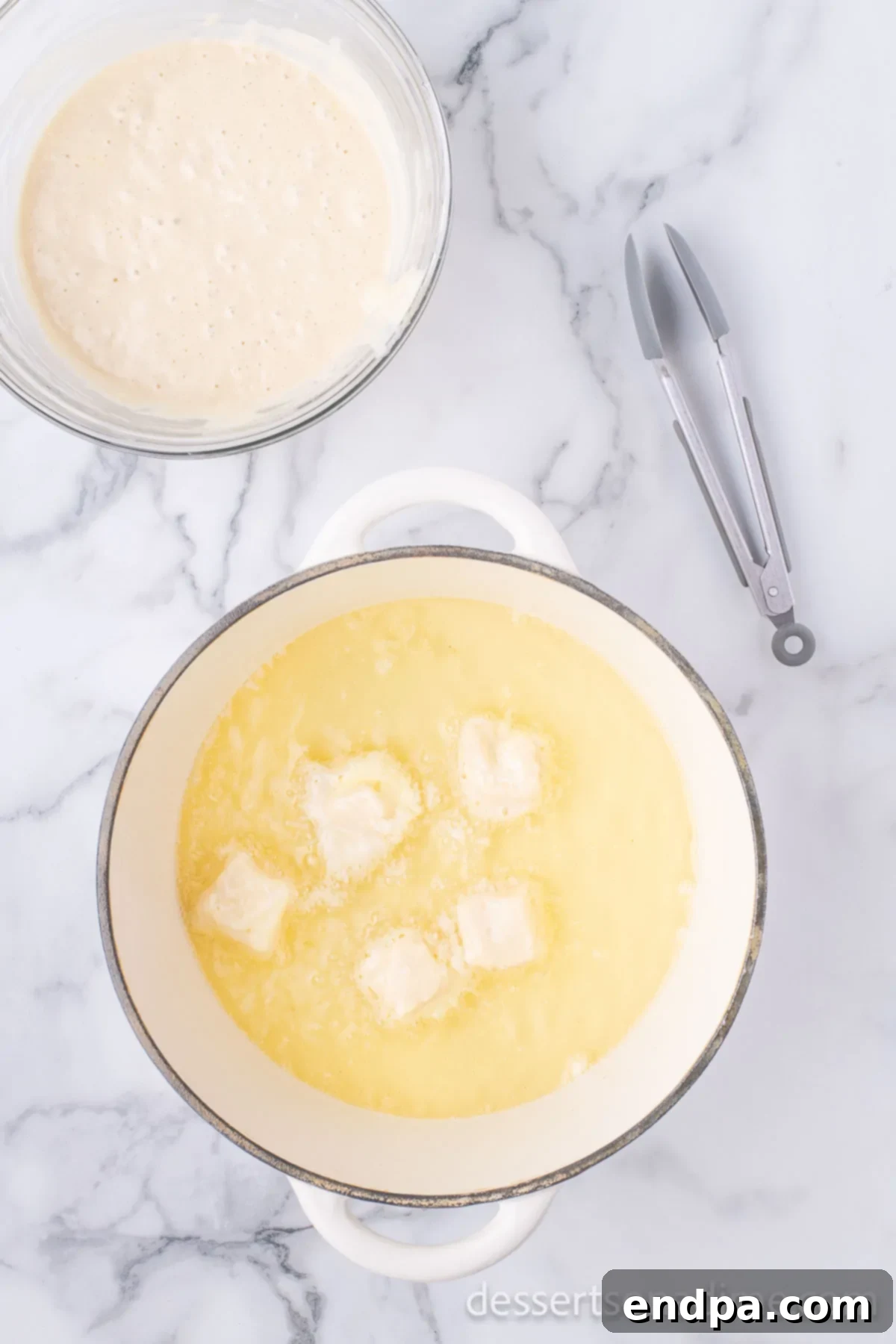 Crispy Cheesecake Indulgence 9 Coated cheesecake bites carefully placed into hot oil for deep frying.