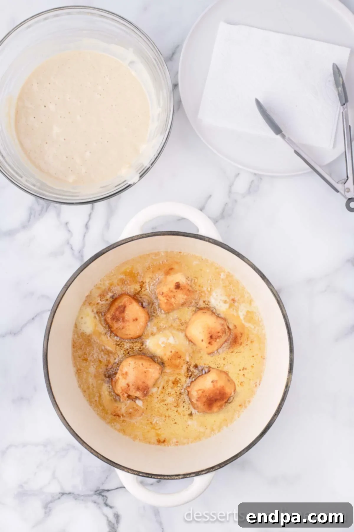 Crispy Cheesecake Indulgence 10 Deep fried cheesecake bites being turned with a slotted spoon in hot oil until golden brown.