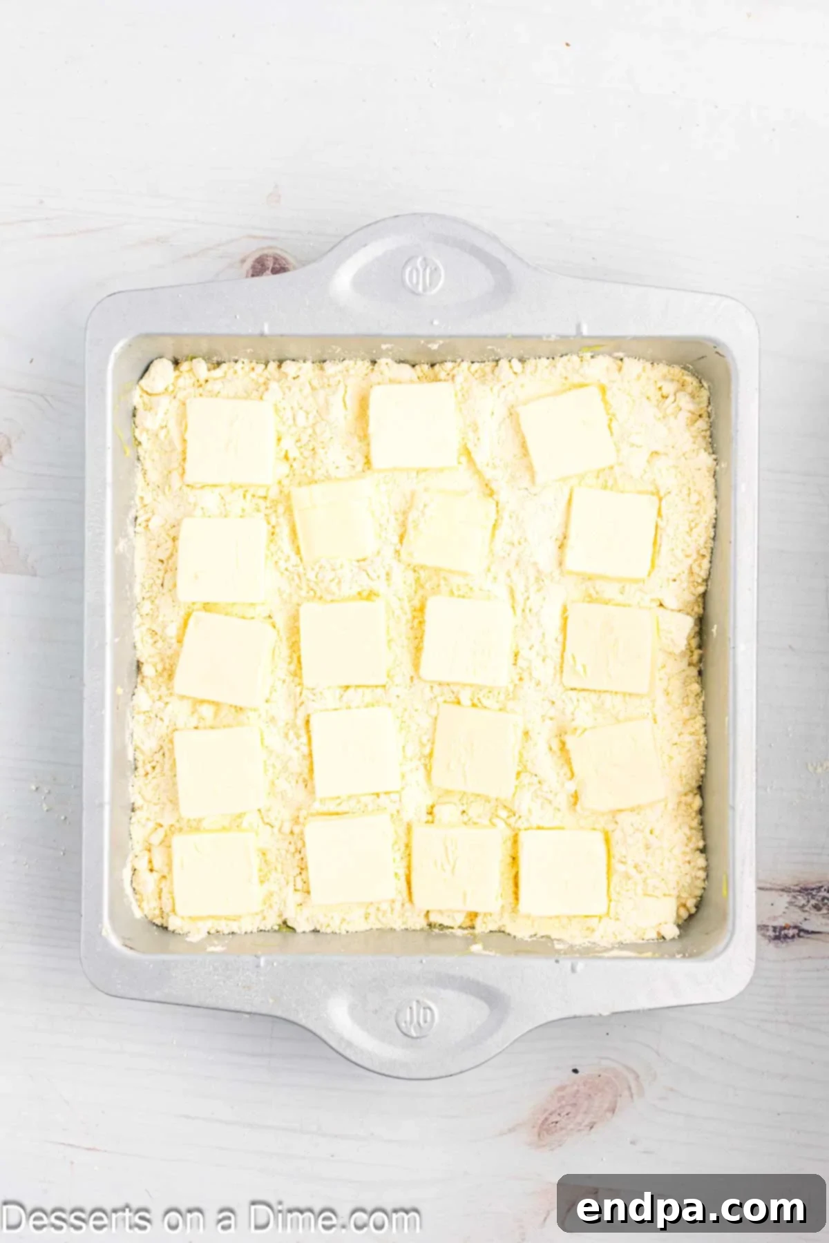 Zesty Lemon Easy Bake 9 Thin slices of cold butter arranged in a single, overlapping layer across the entire surface of the dry cake mix.