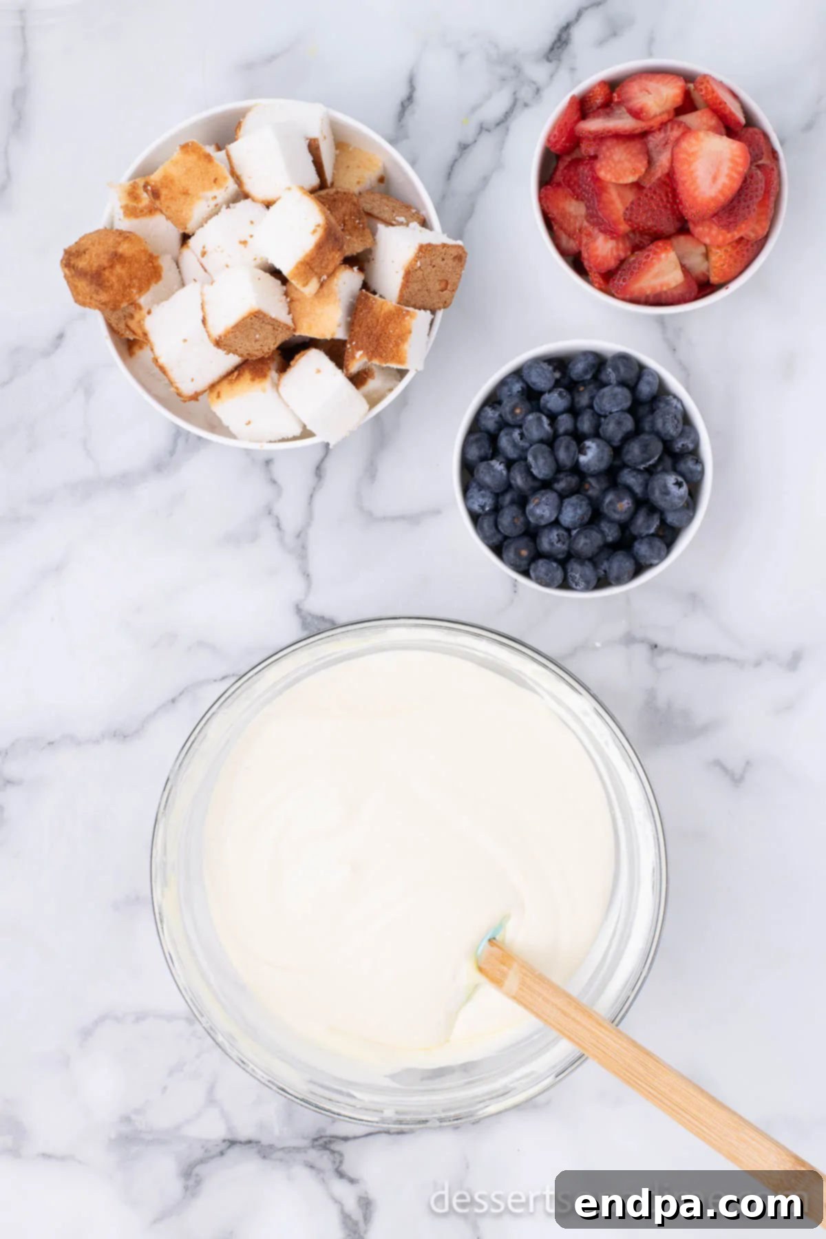 The fully combined, light, and airy pudding, cream cheese, and Cool Whip mixture in a bowl, ready for layering.