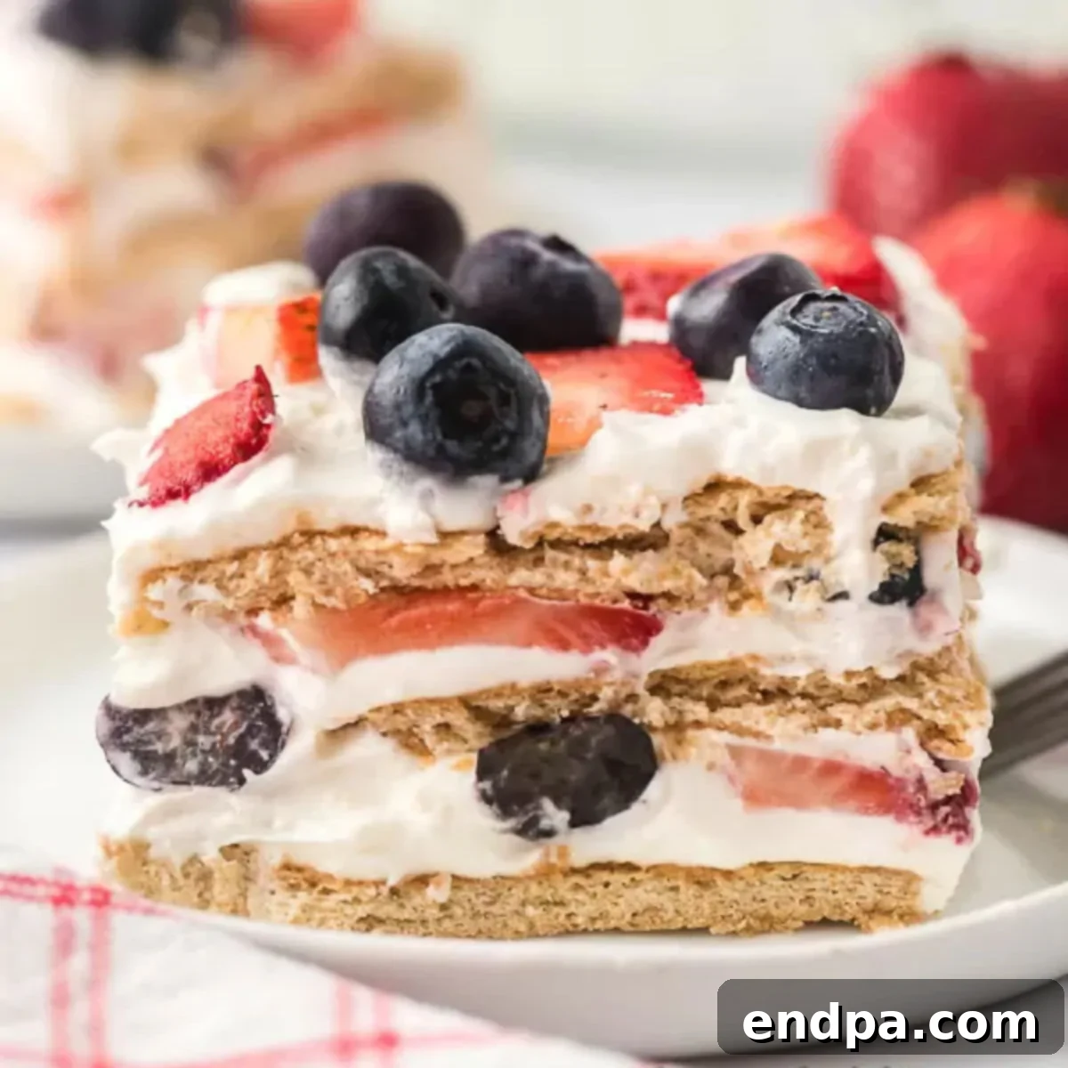 A slice of strawberry, blueberry and cream cake on a plate.