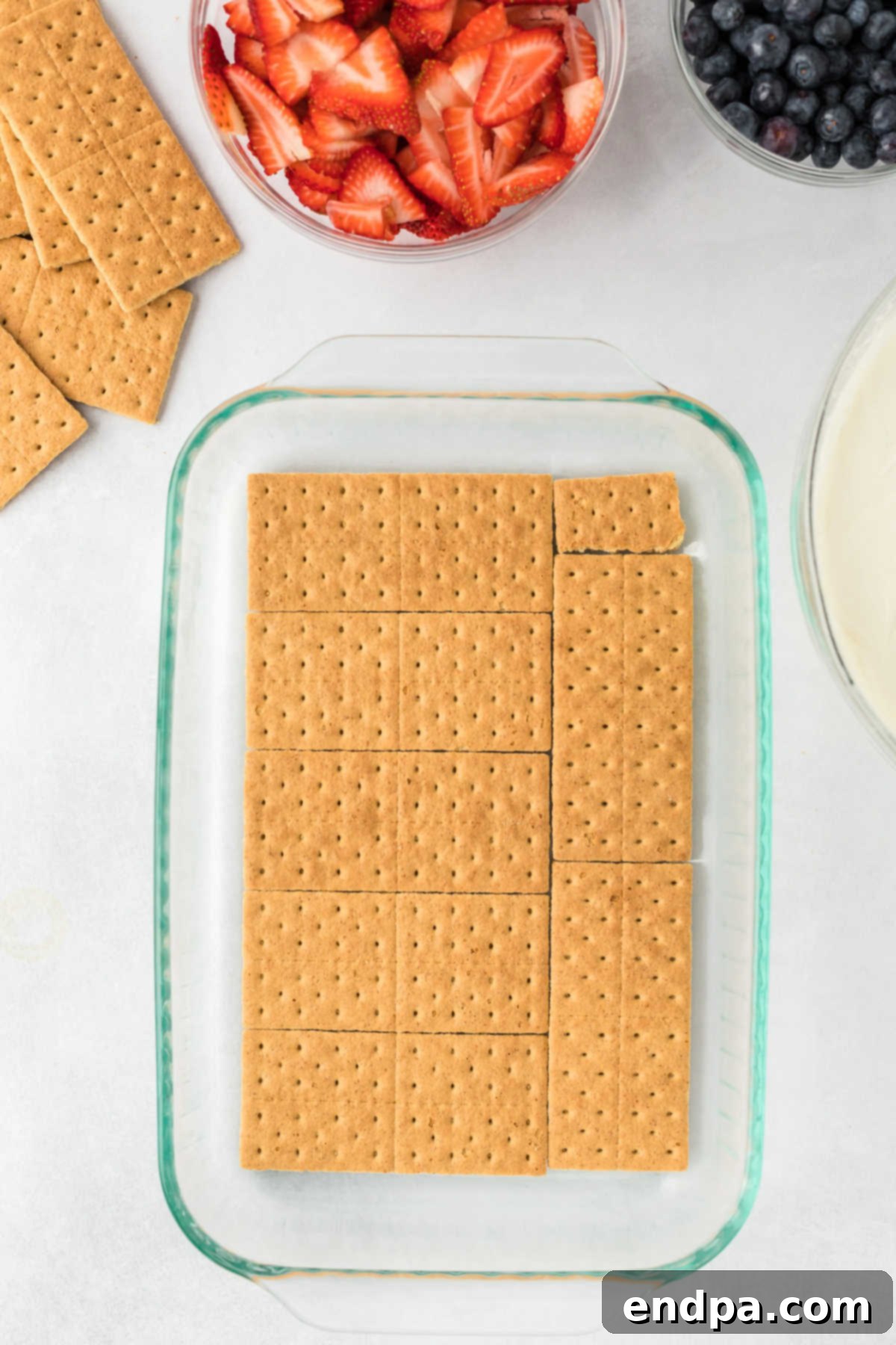A single layer of graham crackers neatly arranged at the bottom of a 9x13 inch baking dish.