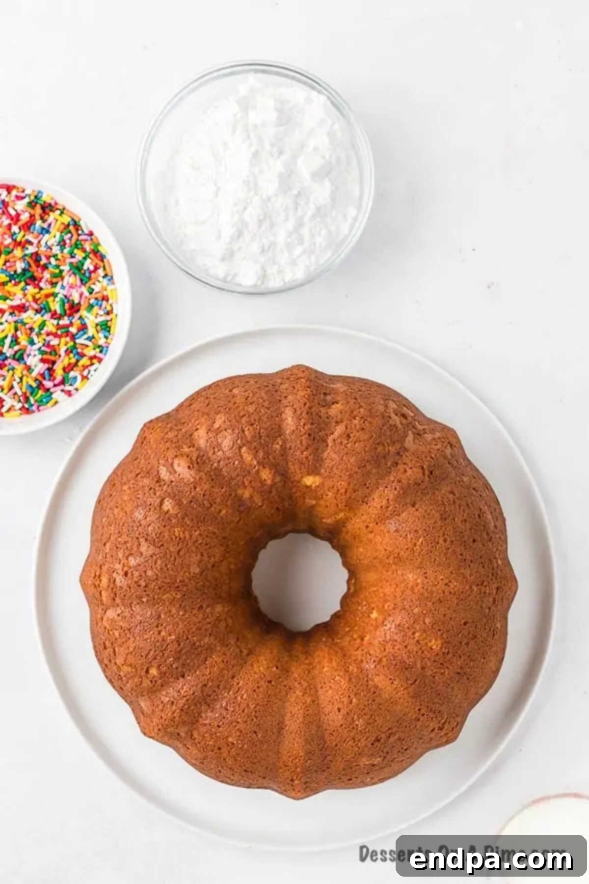 Velvet Ice Cream Cake 6 A freshly baked bundt cake cooling on a wire rack, steam gently rising, showcasing its golden-brown crust.