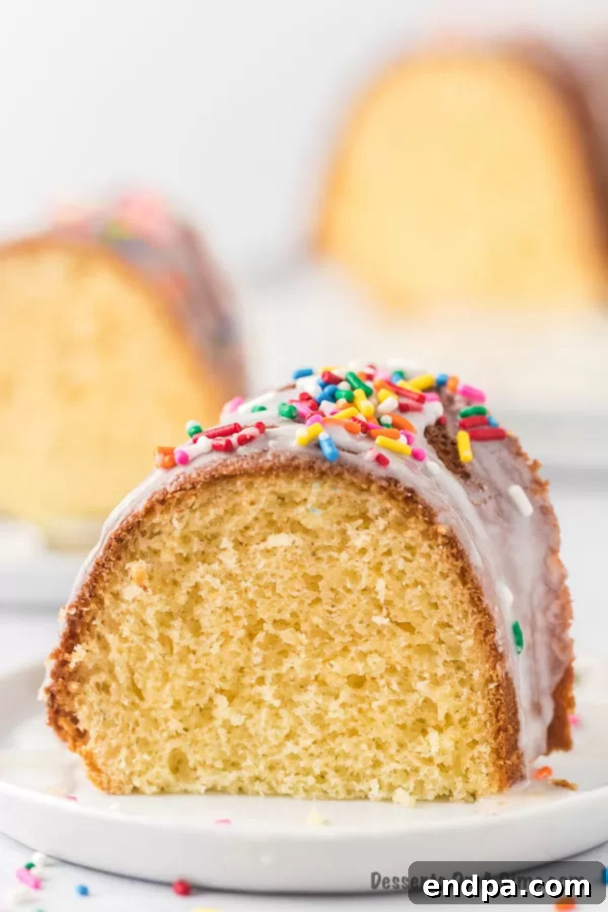 Velvet Ice Cream Cake 10 A vibrant close-up of a slice of melted ice cream cake, showing its tender crumb, festive sprinkles, and a gentle glaze, inviting a taste.