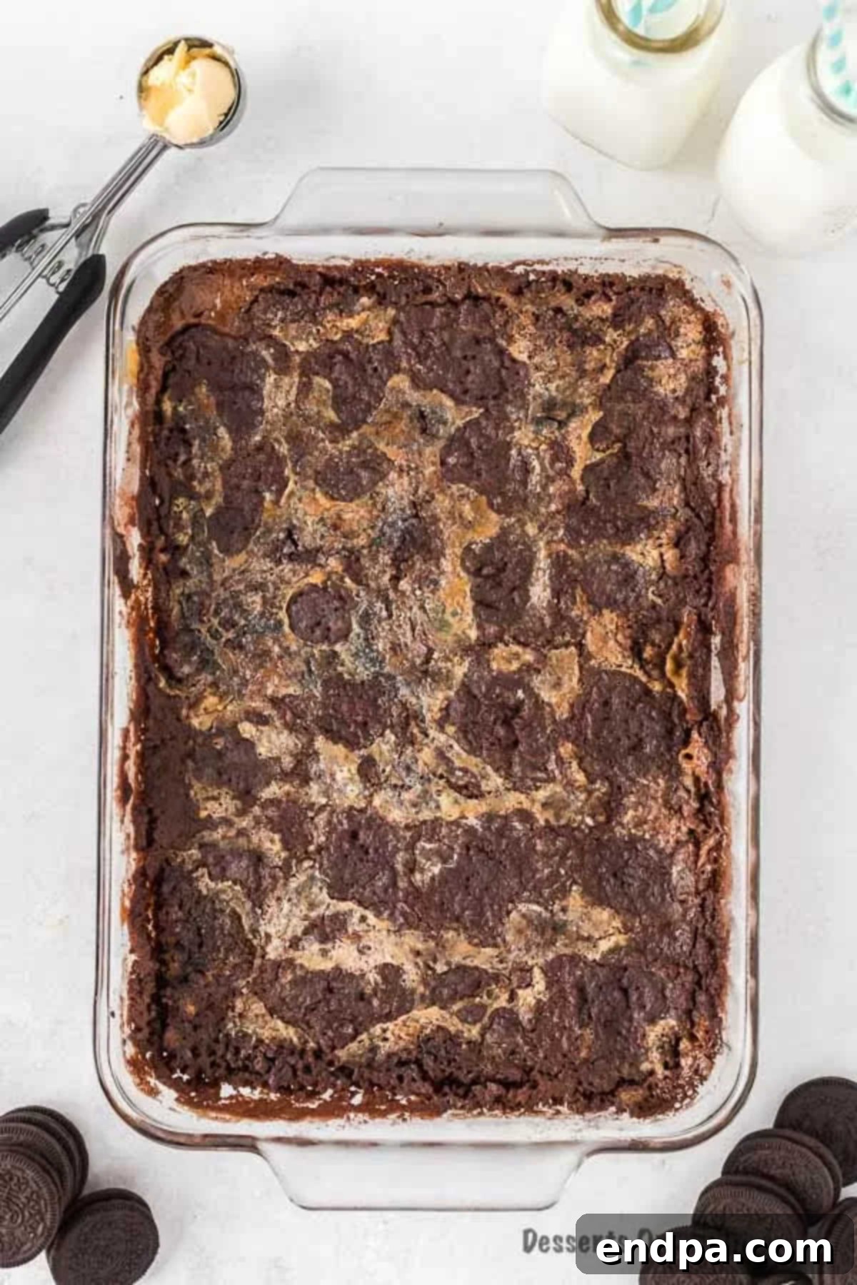 Irresistible Oreo Dump Cake 4 A freshly baked Oreo Dump Cake, golden brown and bubbling, cooling gently in a 9x13 inch baking pan, showcasing its rich, inviting texture and readiness for serving.