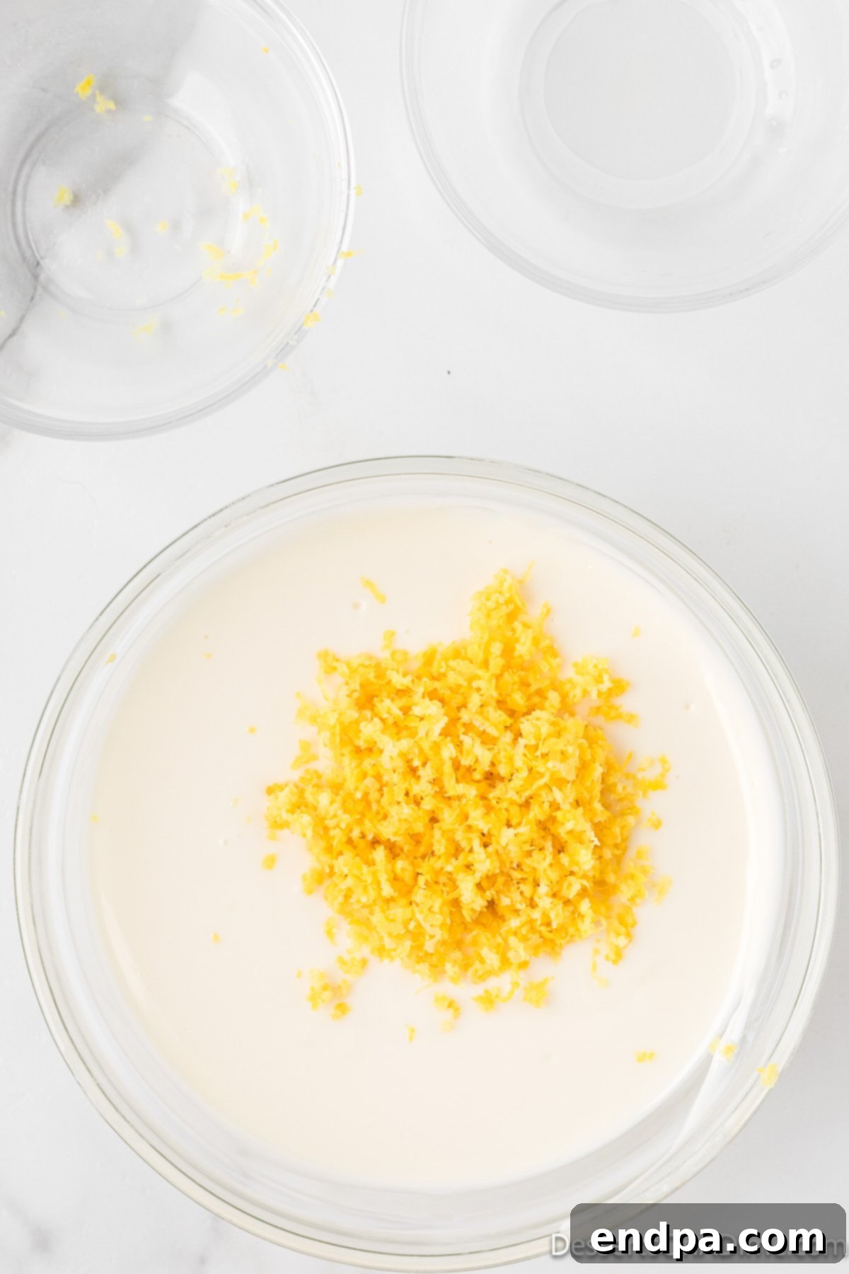 Lemon zest being stirred into melted white chocolate.