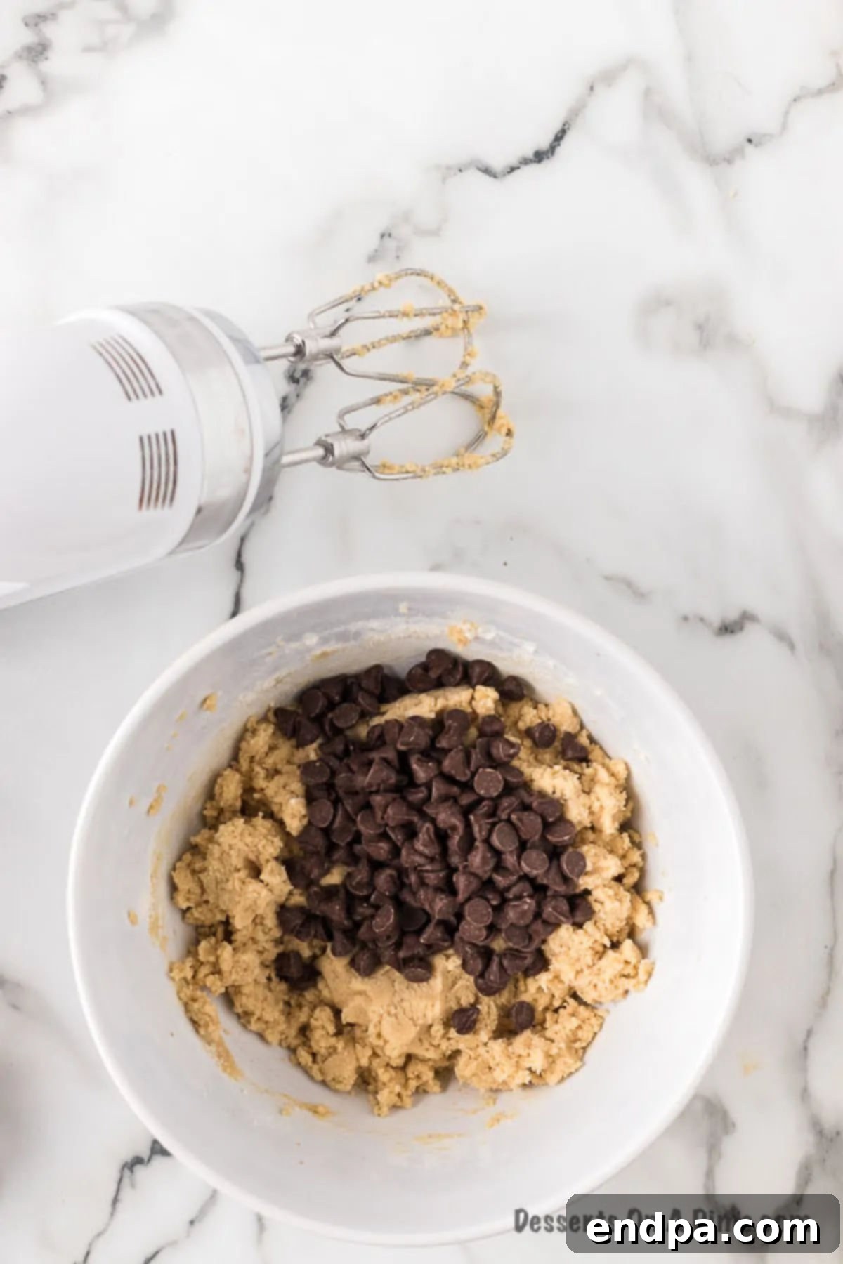 Ready-to-Eat Cookie Dough Dream 6 Heat-treated all-purpose flour and chocolate chips being gently folded into the wet ingredients by hand.