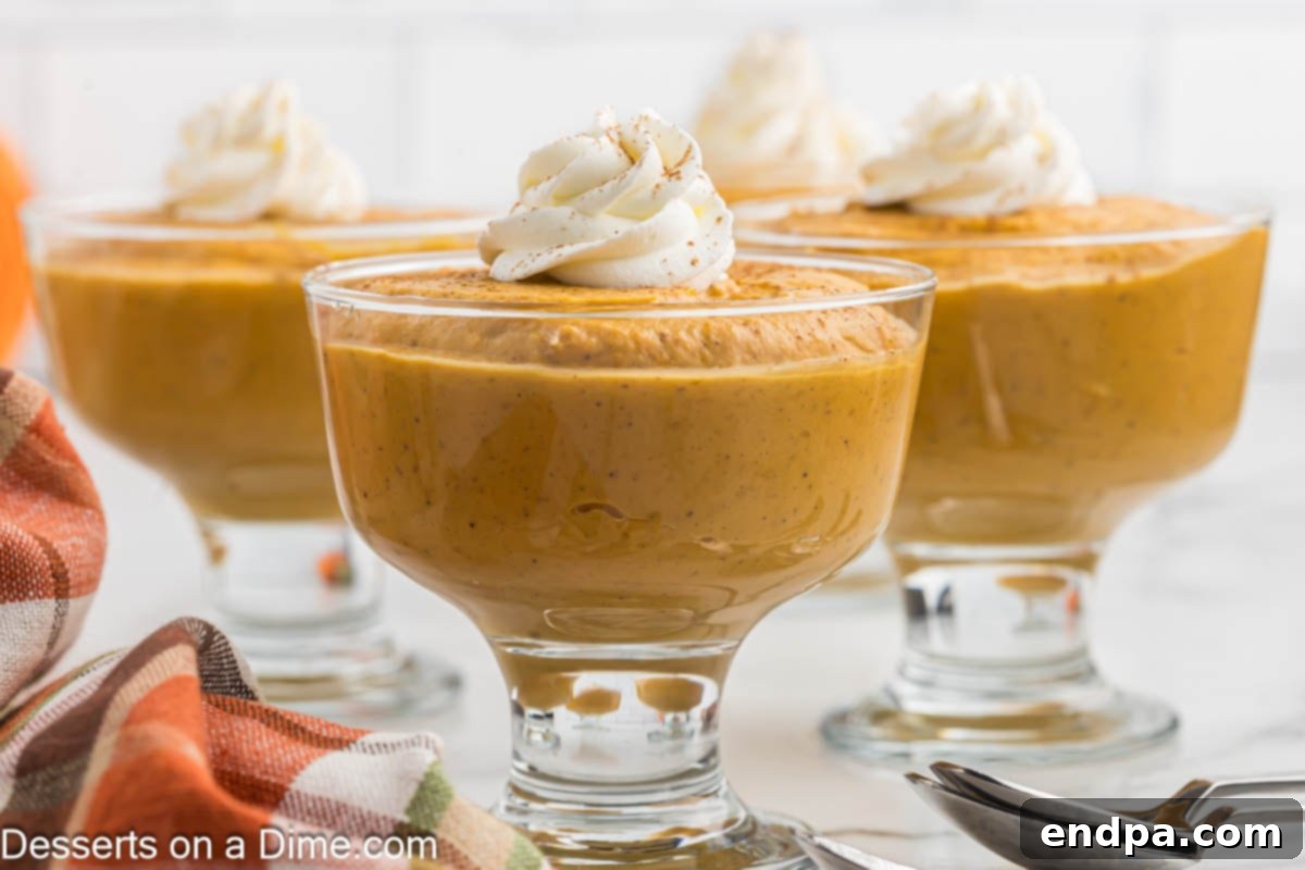 Spiced Pumpkin Dream 2 Containers of pumpkin pudding with whipped cream and a sprinkle of cinnamon, ready to be served.