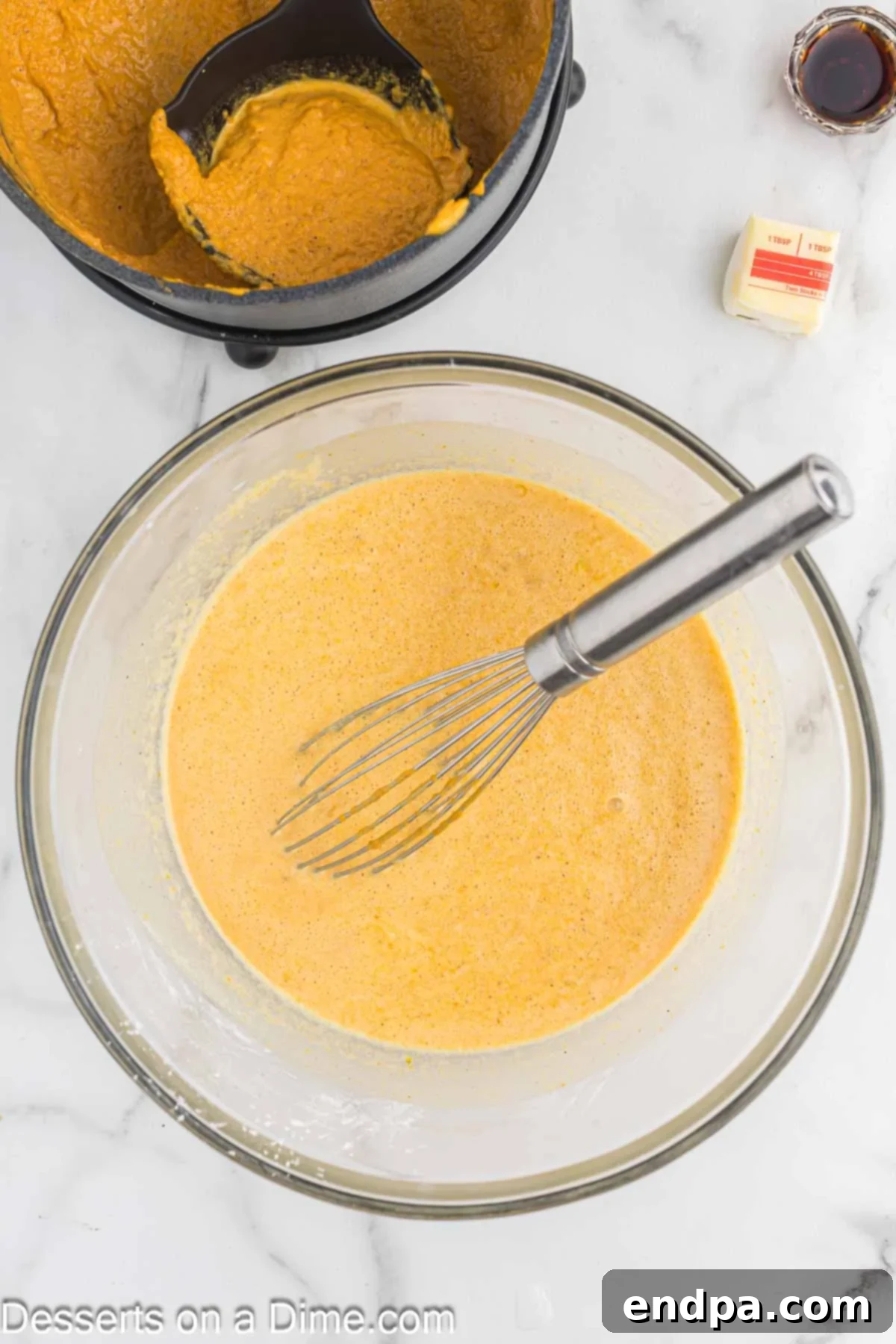 Spiced Pumpkin Dream 7 Hot pumpkin mixture being gradually whisked into the sugar and egg mixture in a bowl to temper the eggs.