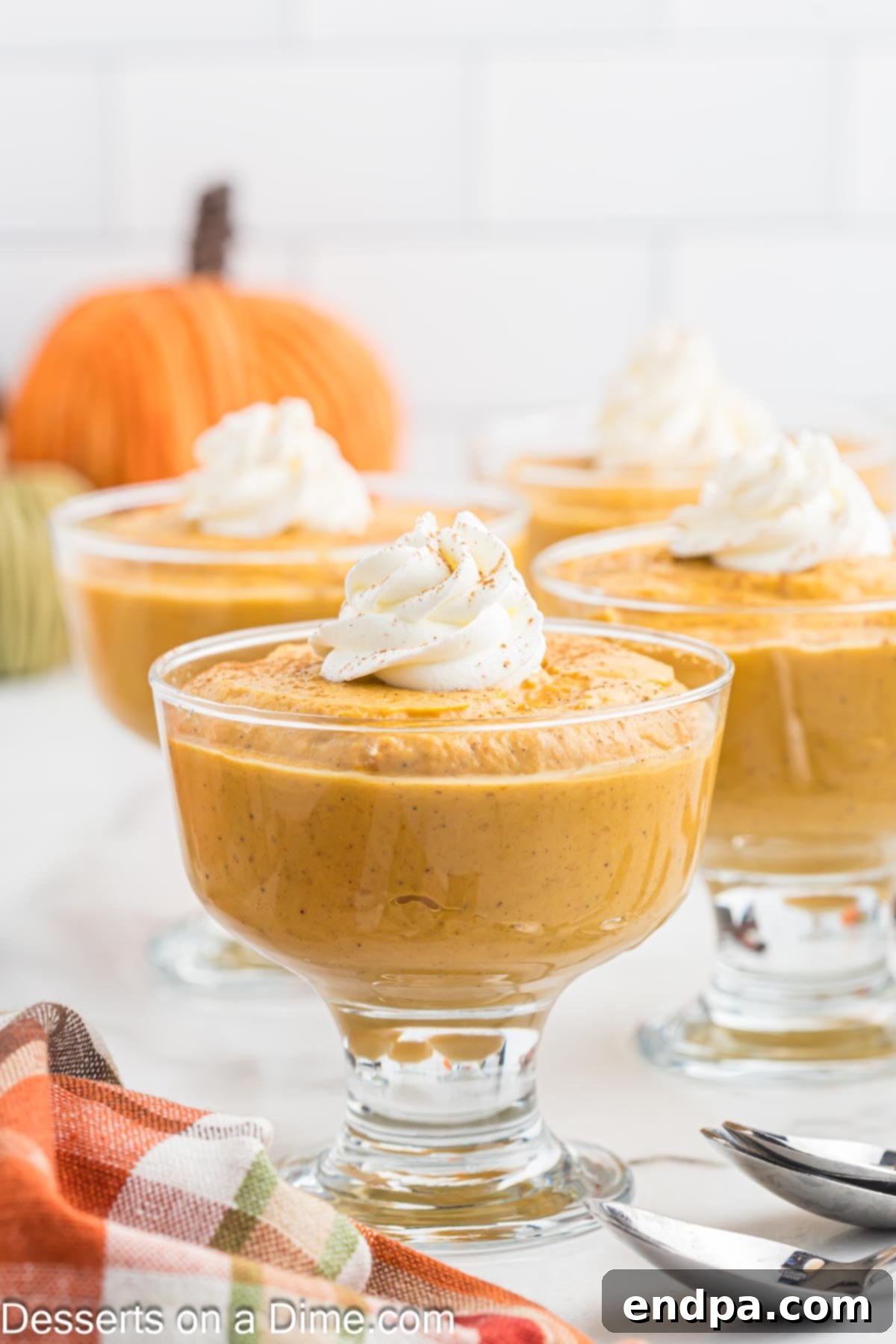 Spiced Pumpkin Dream 9 Pumpkin pudding poured into individual serving dishes, topped with whipped cream and ready to enjoy.