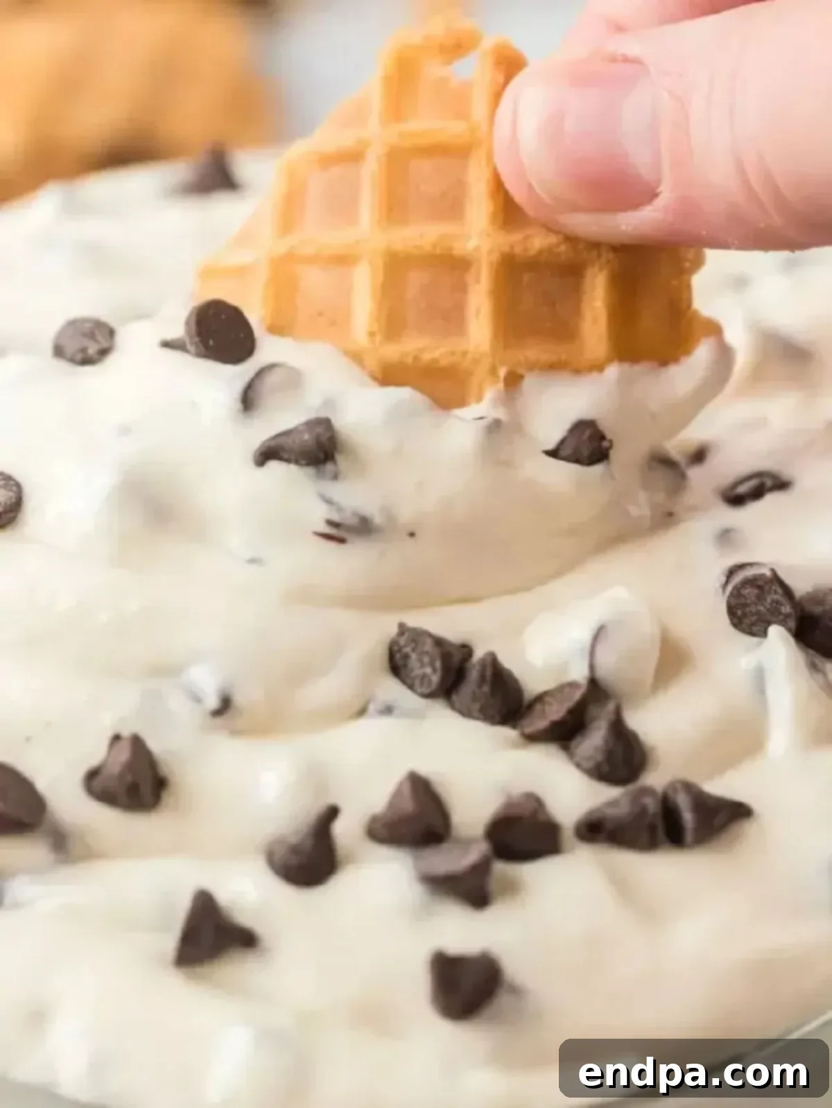 Finished cannoli dip served in a glass bowl, generously topped with an extra sprinkle of miniature chocolate chips for garnish and visual appeal.