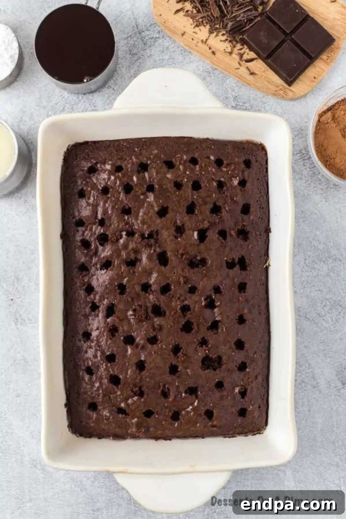 Freshly baked chocolate cake cooling in a 9x13 inch pan, ready for the next step of infusion.