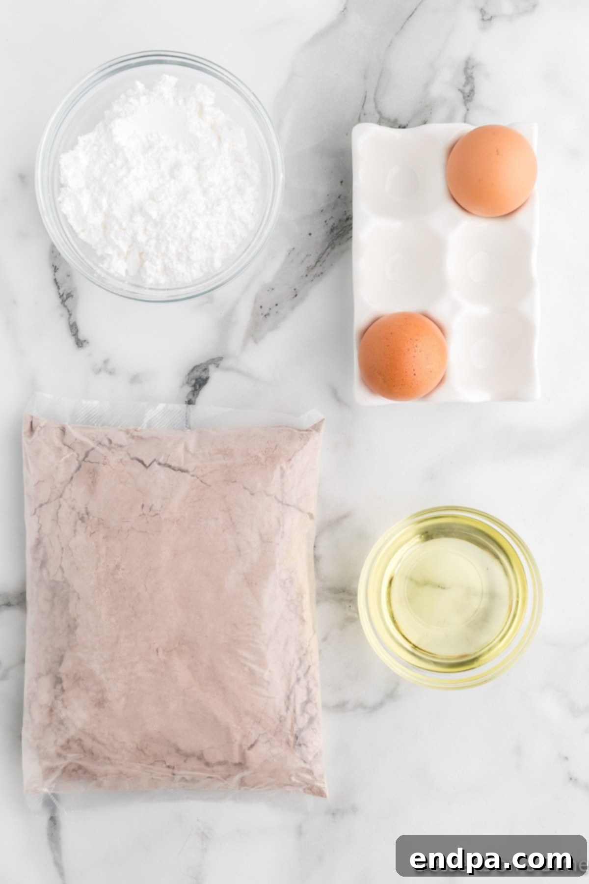 Cracked Cocoa Bliss 3 Ingredients for chocolate crinkle cookies: chocolate cake mix, powdered sugar, eggs, and vegetable oil.