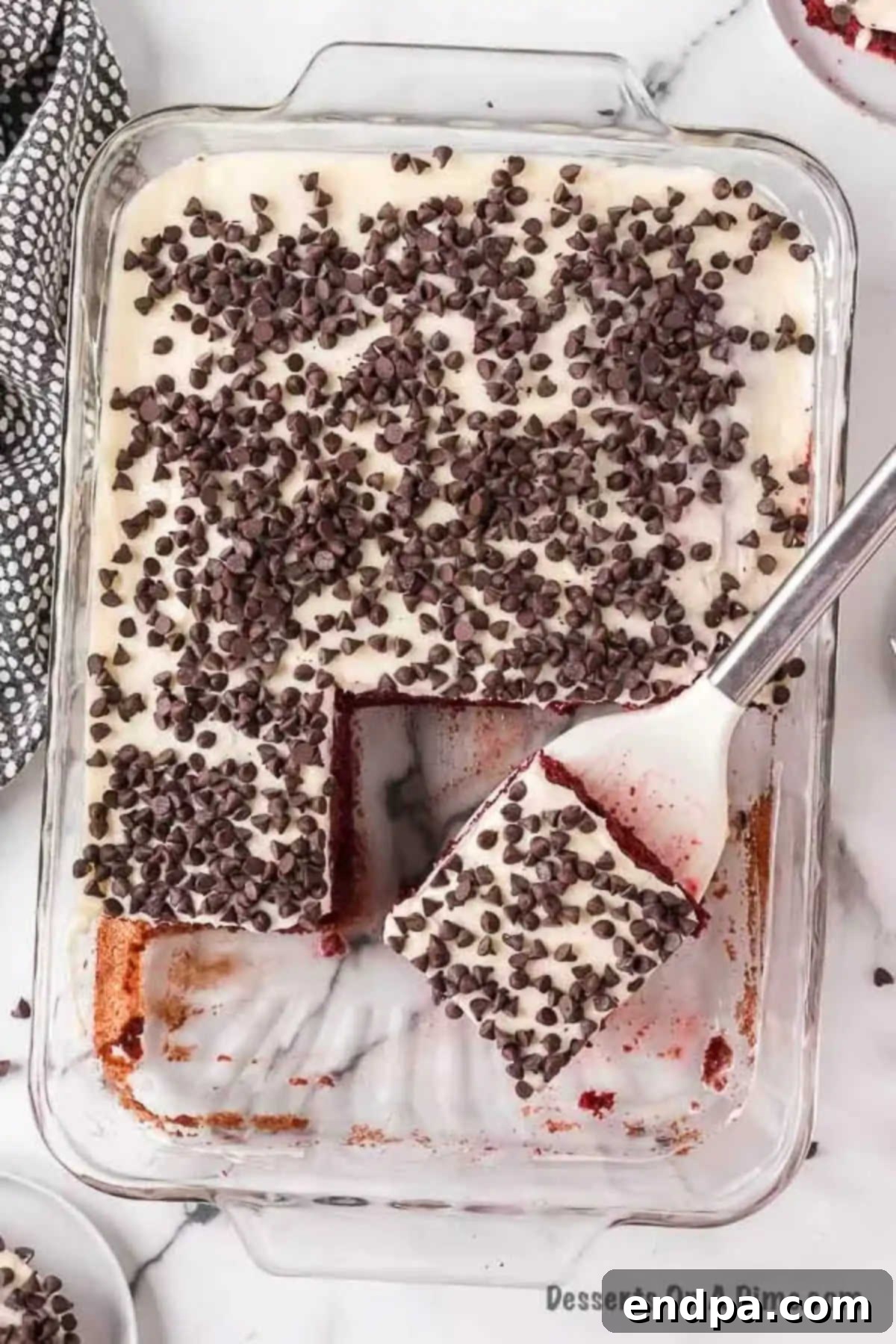 Red Velvet Infusion Cake 10 A slice of Red Velvet Poke Cake being served with a spatula.