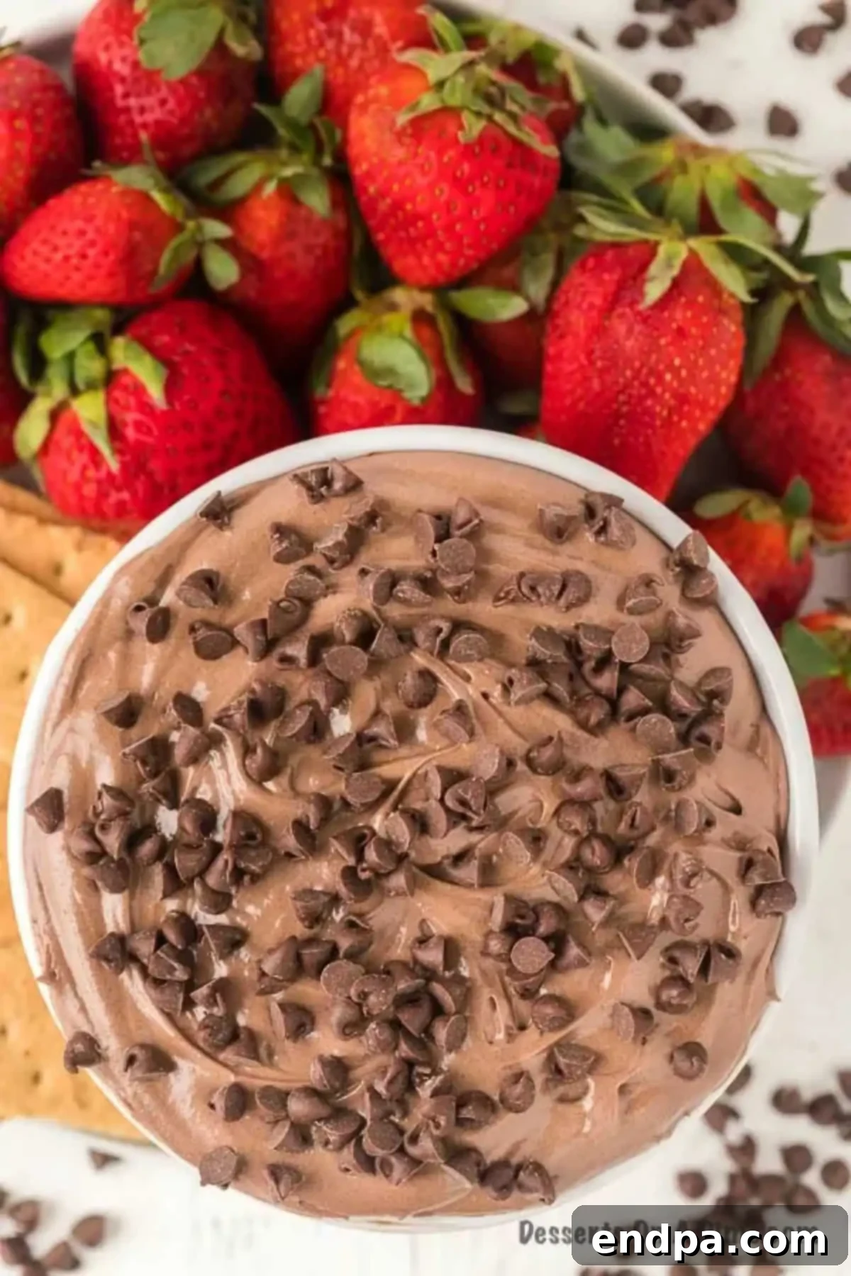 Decadent Brownie Dip 2 Rich brownie batter dip in a bowl, surrounded by fresh strawberries and crunchy graham crackers, ready for dipping.