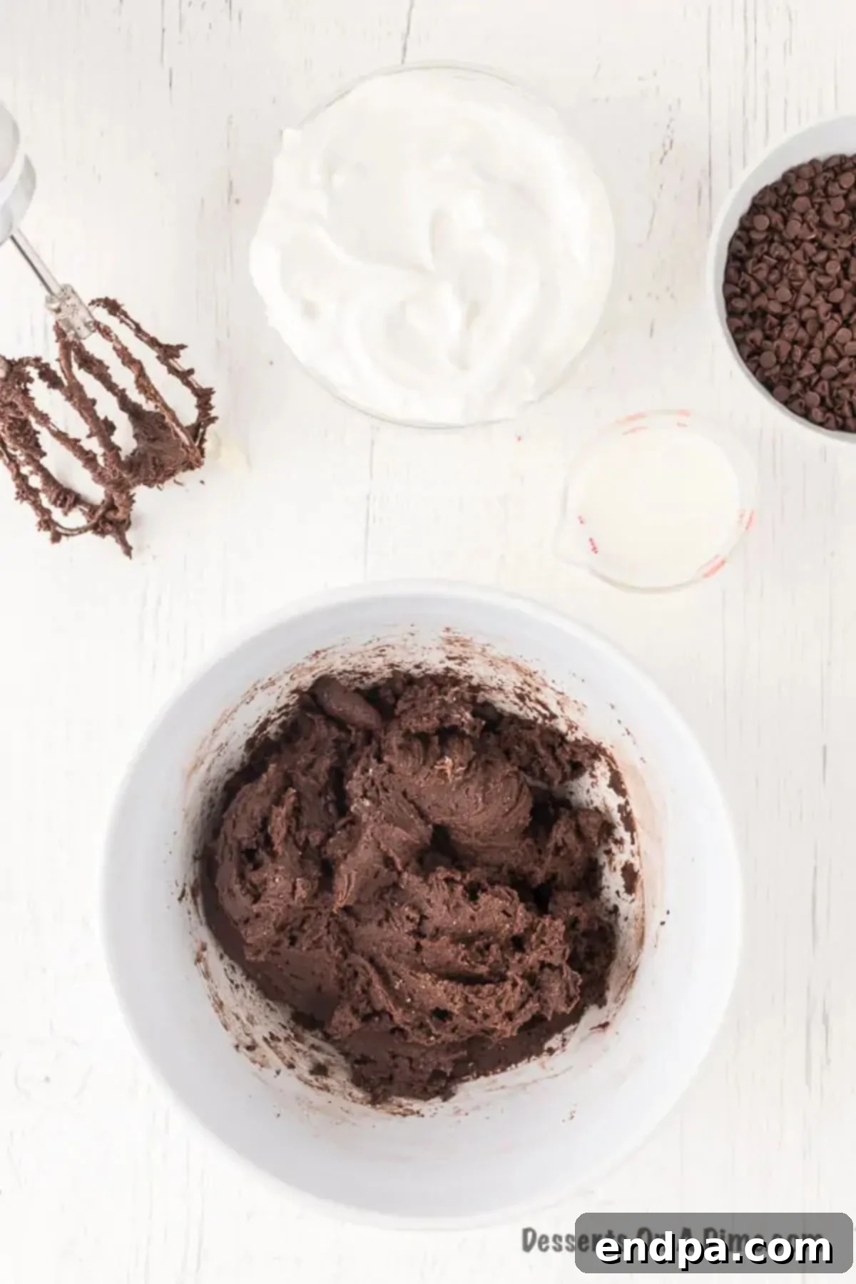 Decadent Brownie Dip 5 Dry brownie mix being gradually added to the beaten cream cheese mixture in a bowl.