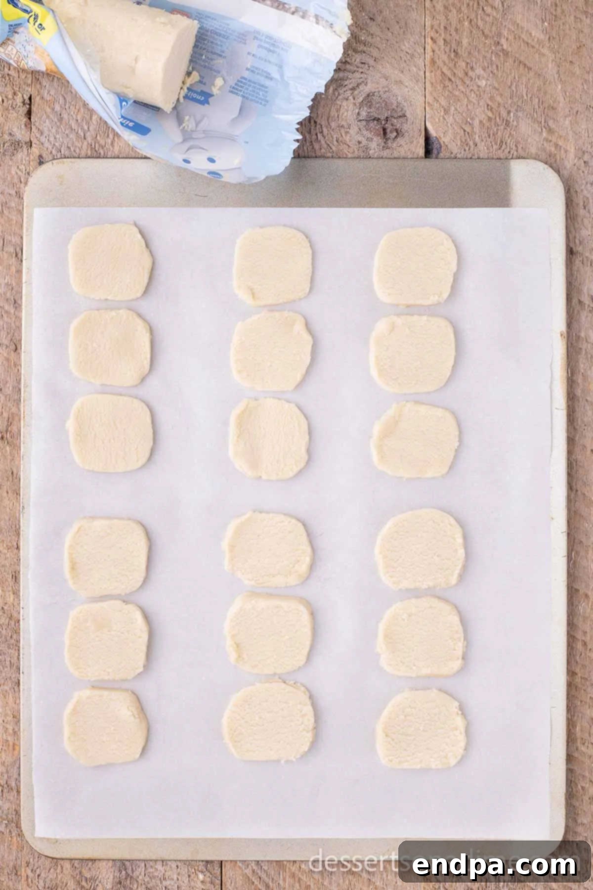 Whip Up Adorable Snowman Cookies 4 Three balls of cookie dough arranged closely on parchment paper, ready to bake into a snowman shape.