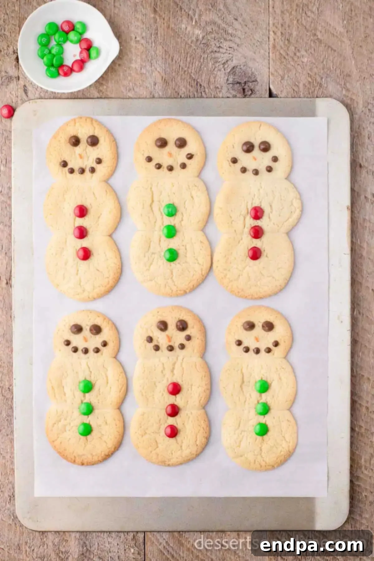Whip Up Adorable Snowman Cookies 7 A snowman cookie decorated with various candies for buttons and facial features.