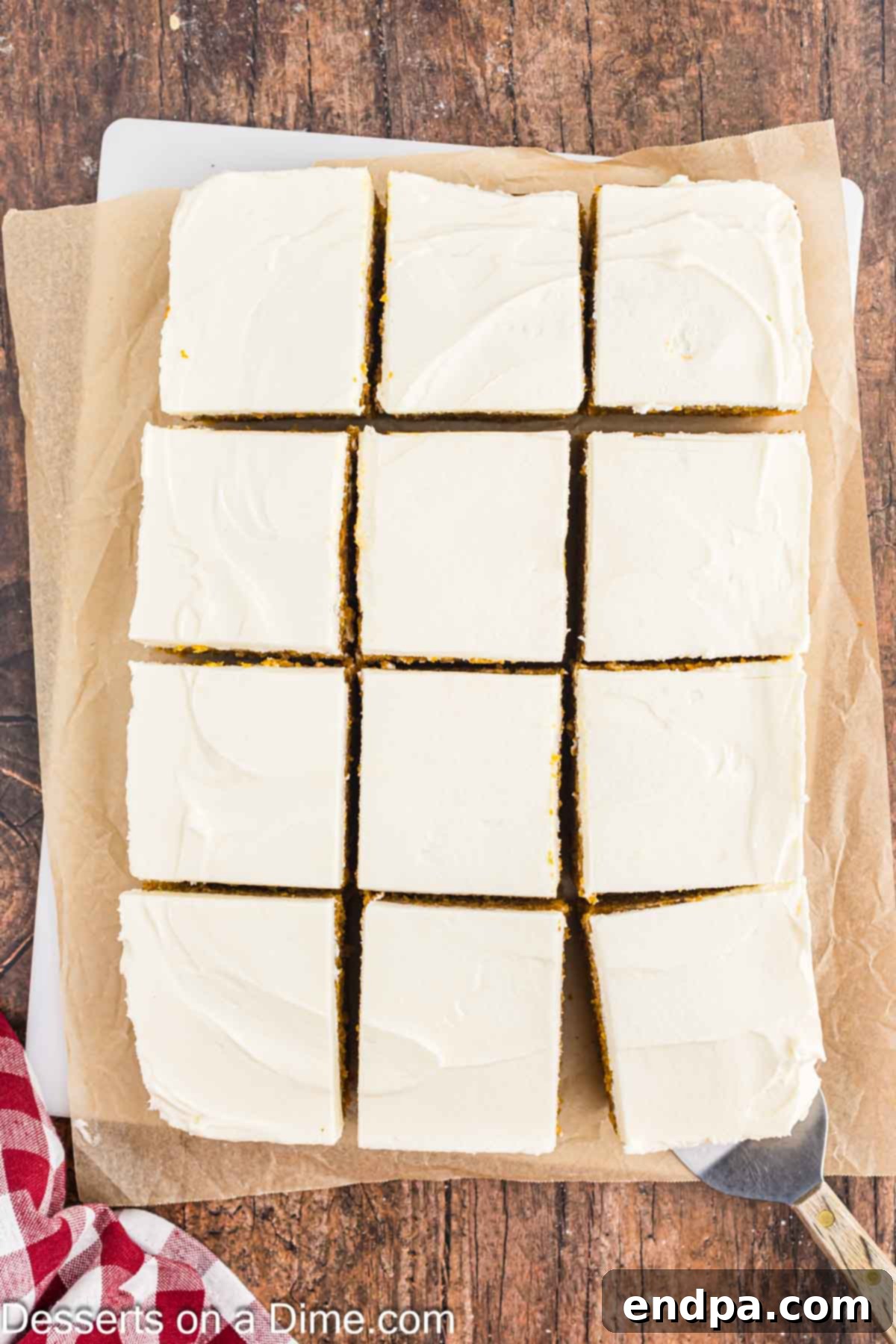 The rich cream cheese frosting beautifully spread over the cooled pumpkin bars, which are then cut into neat, delicious squares.