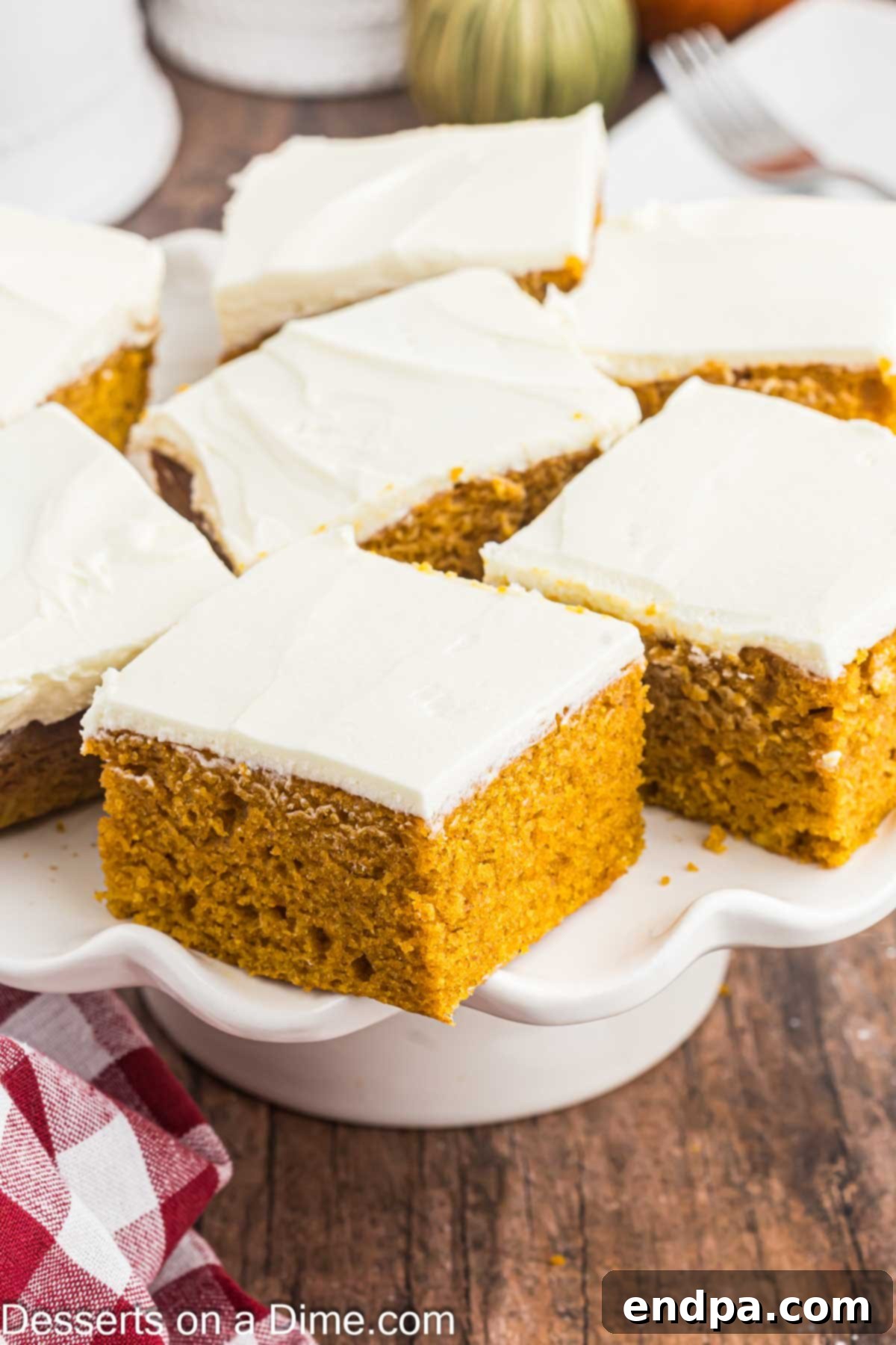 Perfectly cut squares of Paula Deen Pumpkin Bars, frosted and ready to be enjoyed, arranged on a beautiful serving platter.