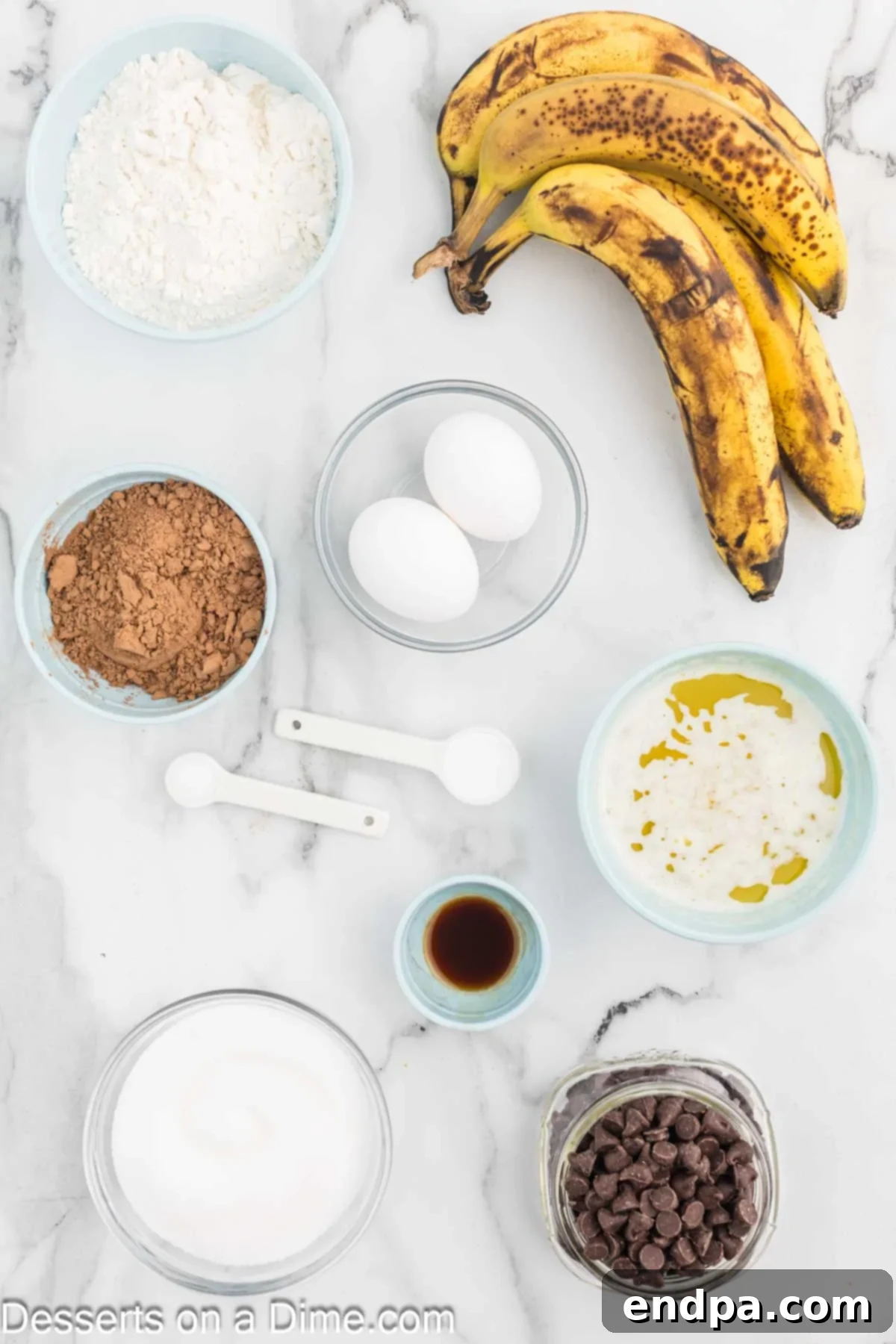 Ultimate Chocolate Banana Loaf 3 Gathered ingredients for Chocolate Banana Bread: flour, cocoa powder, baking soda, bananas, butter, eggs, vanilla extract, and chocolate chips.