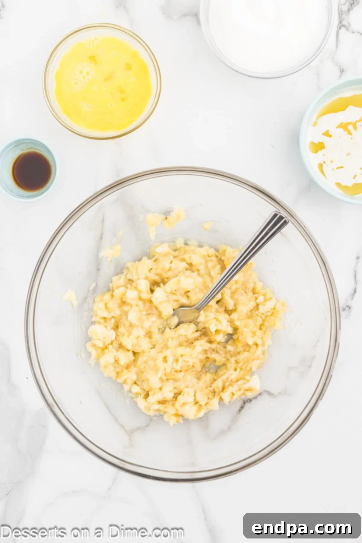 Ultimate Chocolate Banana Loaf 4 Ripe bananas in a bowl being mashed with a fork.