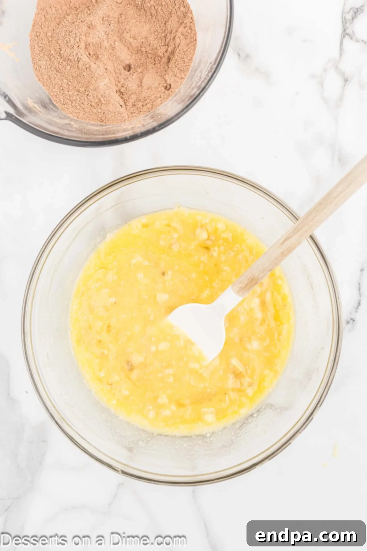 Ultimate Chocolate Banana Loaf 5 Melted butter, beaten eggs, and sugar being stirred into mashed bananas.