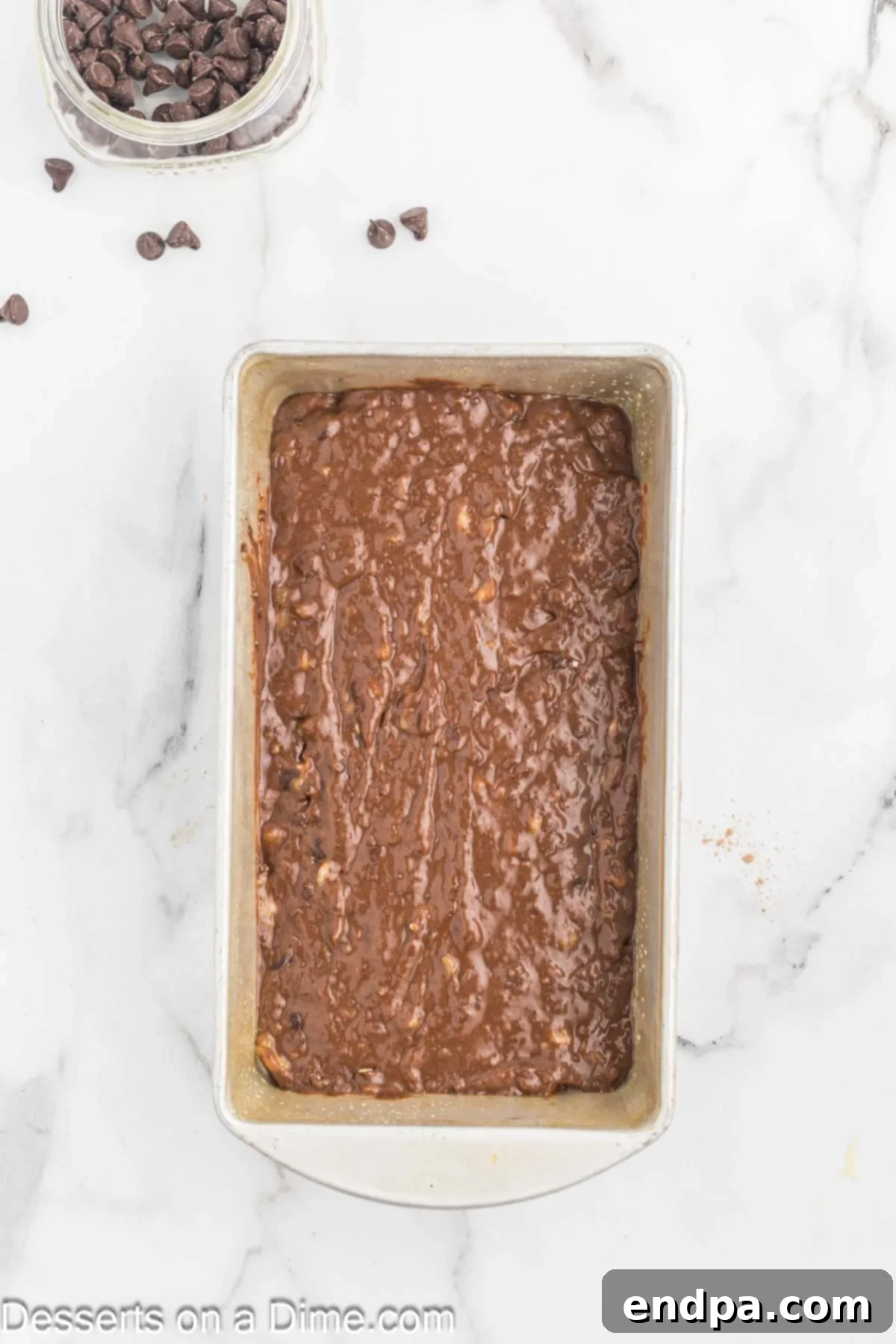 Ultimate Chocolate Banana Loaf 8 Chocolate banana bread batter evenly spread into a loaf pan, ready for baking.