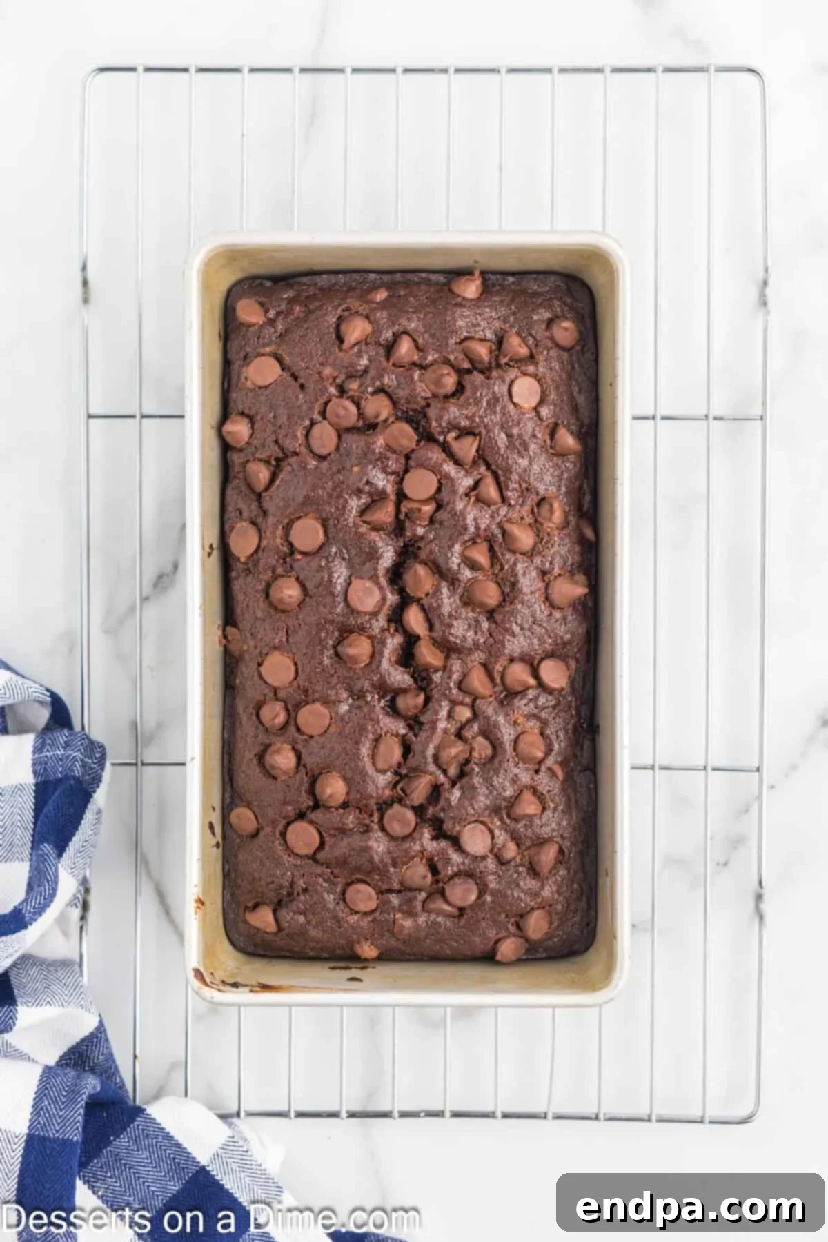 Ultimate Chocolate Banana Loaf 10 A freshly baked loaf of Chocolate Banana Bread cooling in its pan on a wire rack.