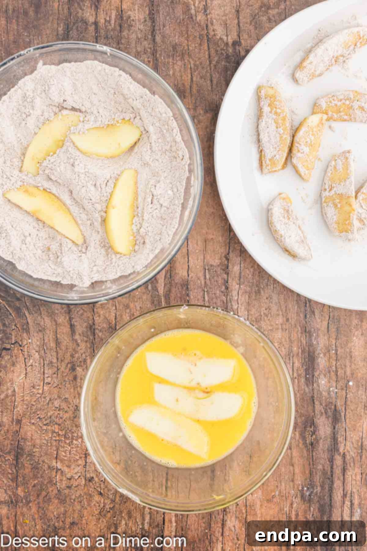 Apple slices being coated in egg mixture. 