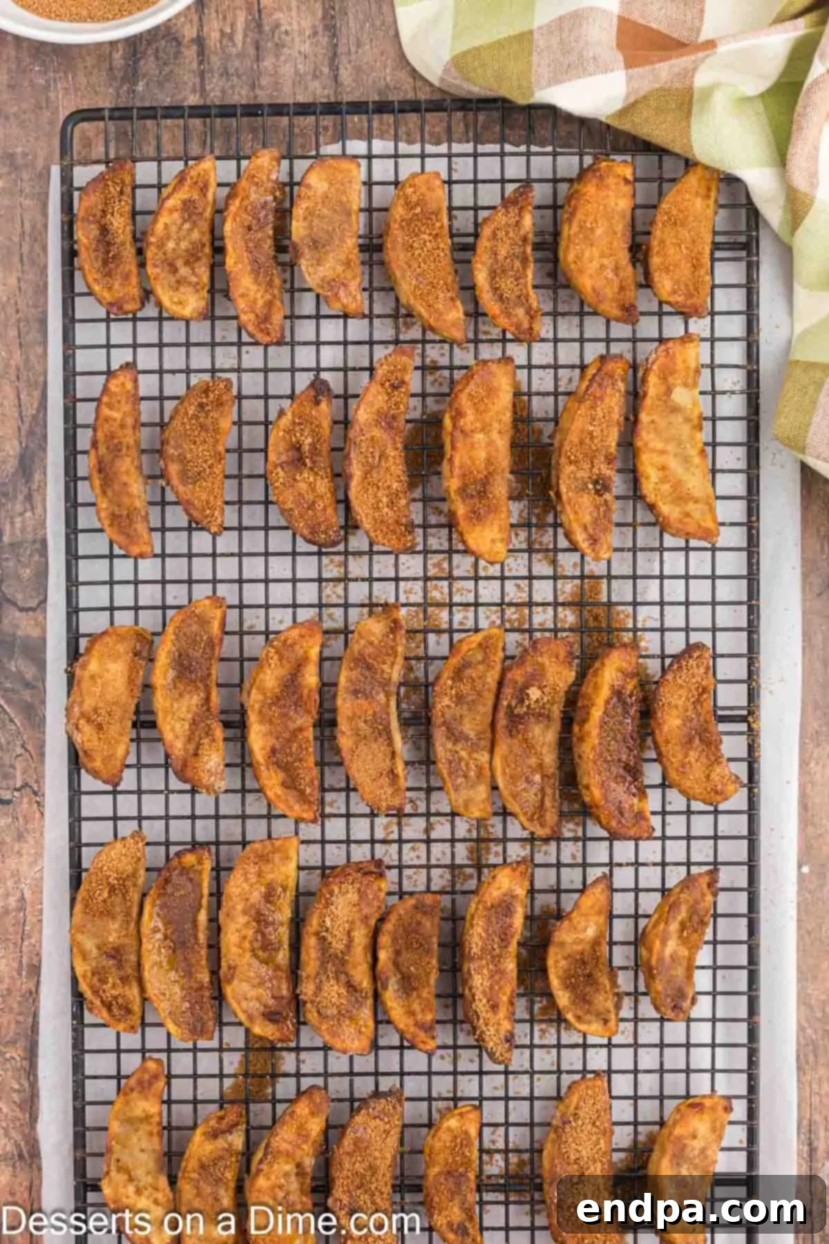 Fried apple slices on wire rack with cinnamon sugar coating. 