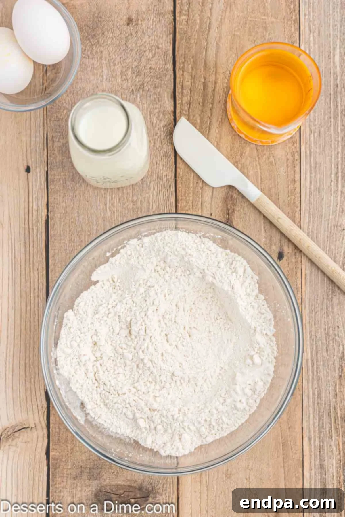 A white bowl containing dry ingredients for funnel cake batter: all-purpose flour, granulated sugar, and baking powder, with salt sprinkled in.