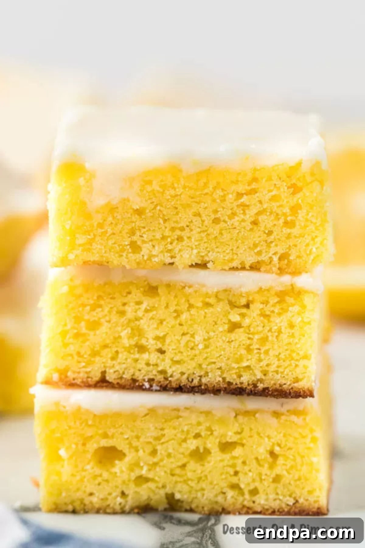 Homemade Lemon Brownies stacked together, showcasing their zesty glaze.