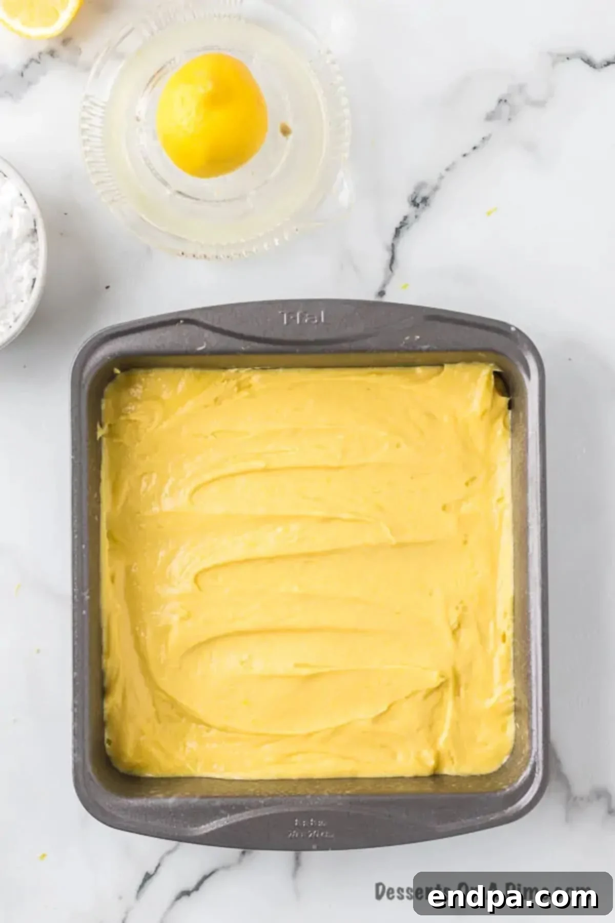 Lemon brownie batter spread evenly into a baking pan.