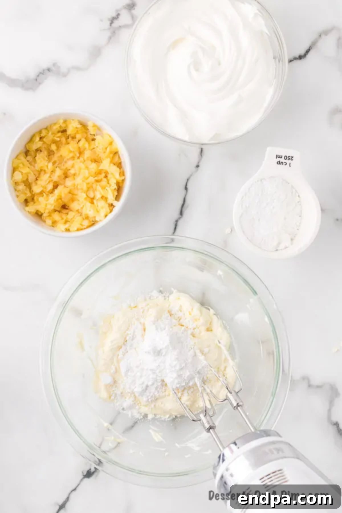 Cream cheese and softened butter beaten together in a large mixing bowl, appearing smooth and creamy.