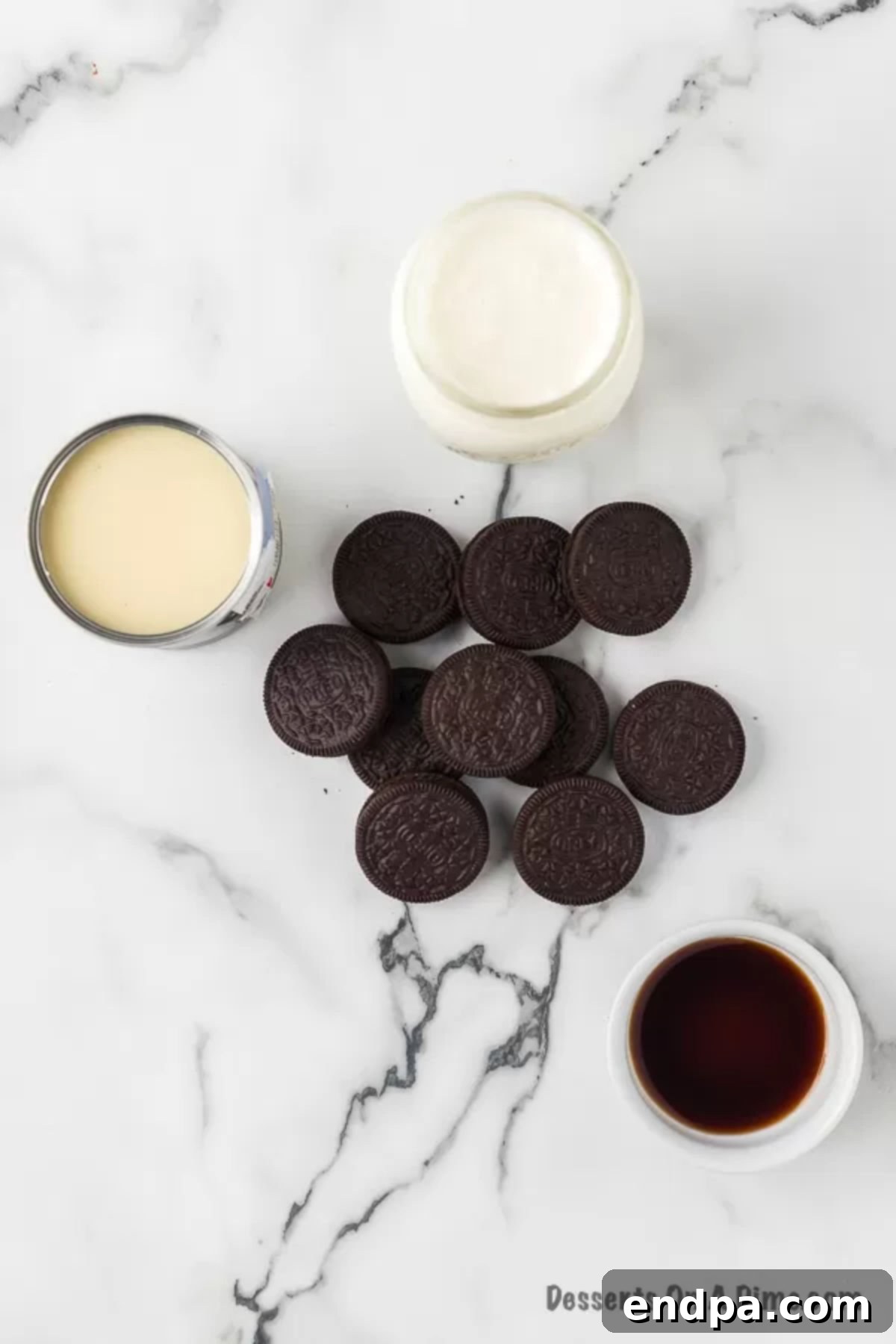 Midnight Cookie Swirl Ice Cream 3 Ingredients for ice cream - sweetened condensed milk, vanilla, heavy whipping cream, Oreo cookies laid out on a table.