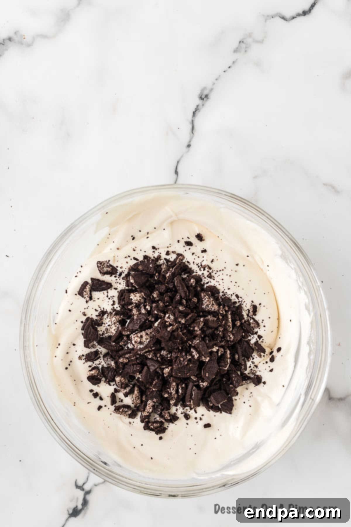 Midnight Cookie Swirl Ice Cream 8 Crushed Oreo cookies being folded into the ice cream base mixture.