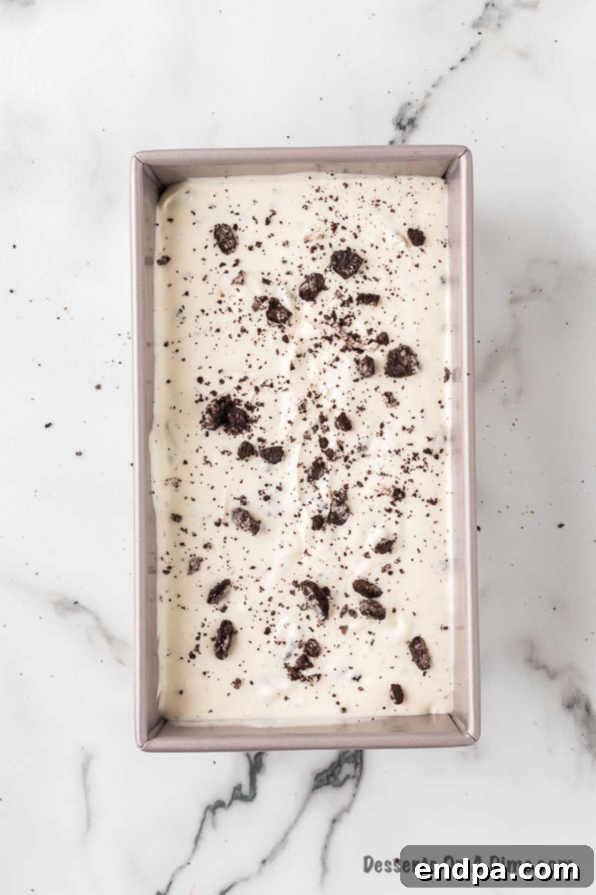 Midnight Cookie Swirl Ice Cream 9 Ice cream mixture in a 9-inch loaf pan, covered with plastic wrap, ready for the freezer.