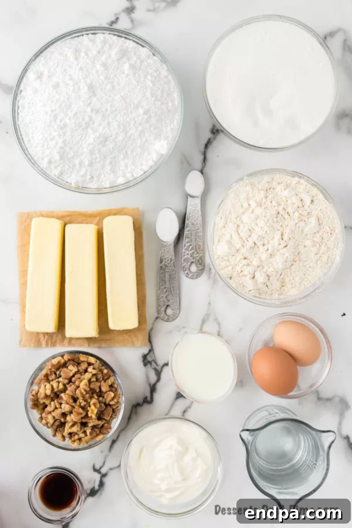 A selection of ingredients for White Texas Sheet Cake: flour, sugar, baking soda, sour cream, eggs, and butter.